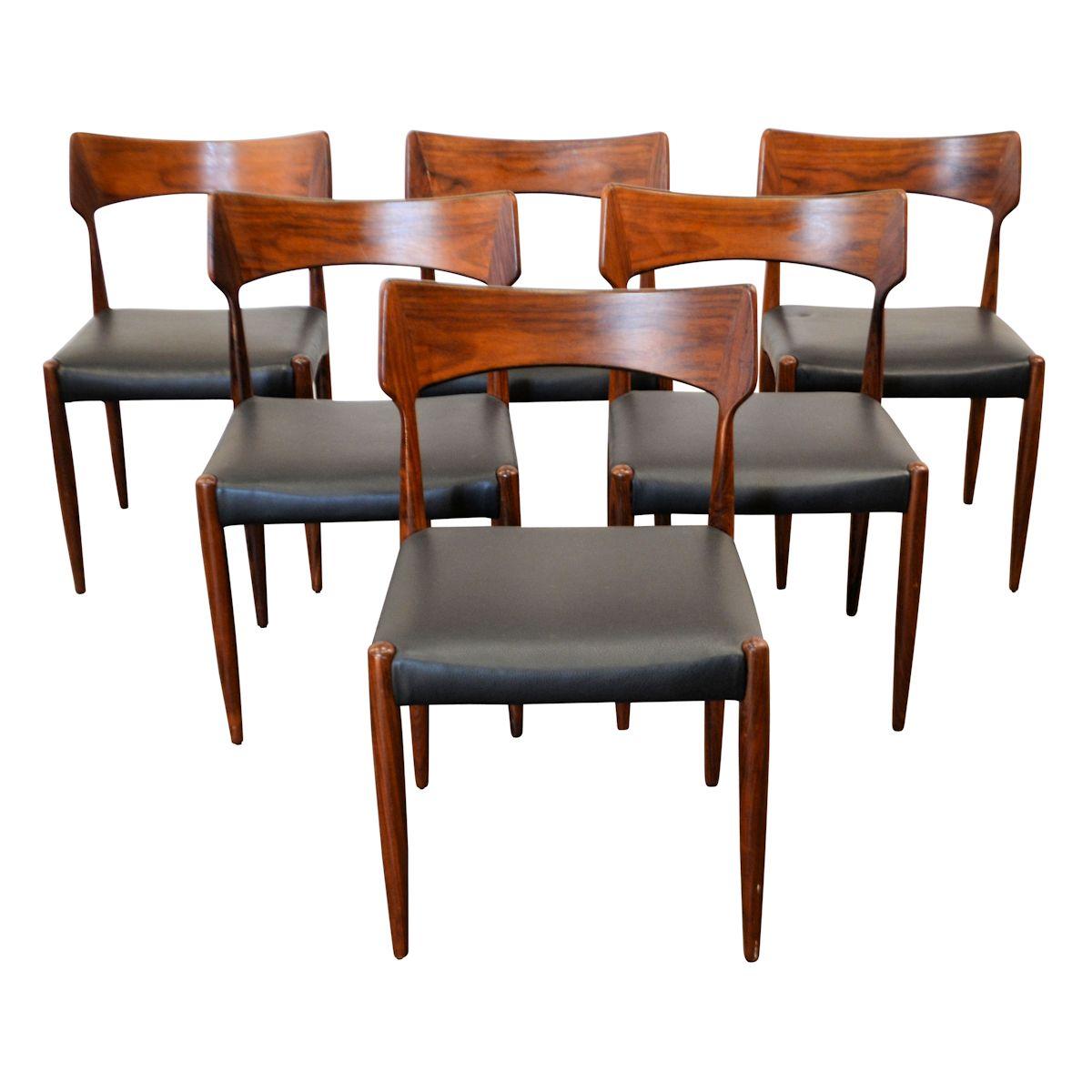 Set of six vintage Danish dining chairs designed and manufactured by Bernhard Pedersen & Son, Denmark. These solid rosewood chairs feature a typical vintage Danish design, gracefully sculpted backrests and black leather seats. High quality design