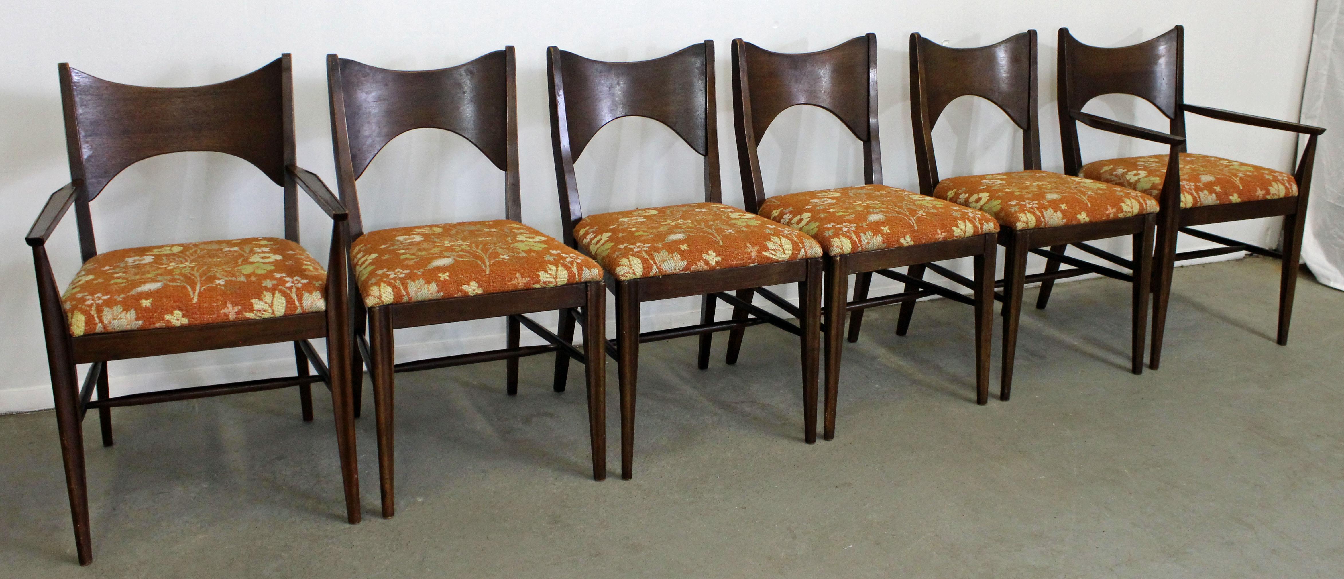 What a find. Offered is a set of 6 walnut dining chairs, including four side chairs and two armchairs. We believe they are made in the style of Paul McCobb by Broyhill, due to the tapering of arms and legs, but they aren't signed. They are good