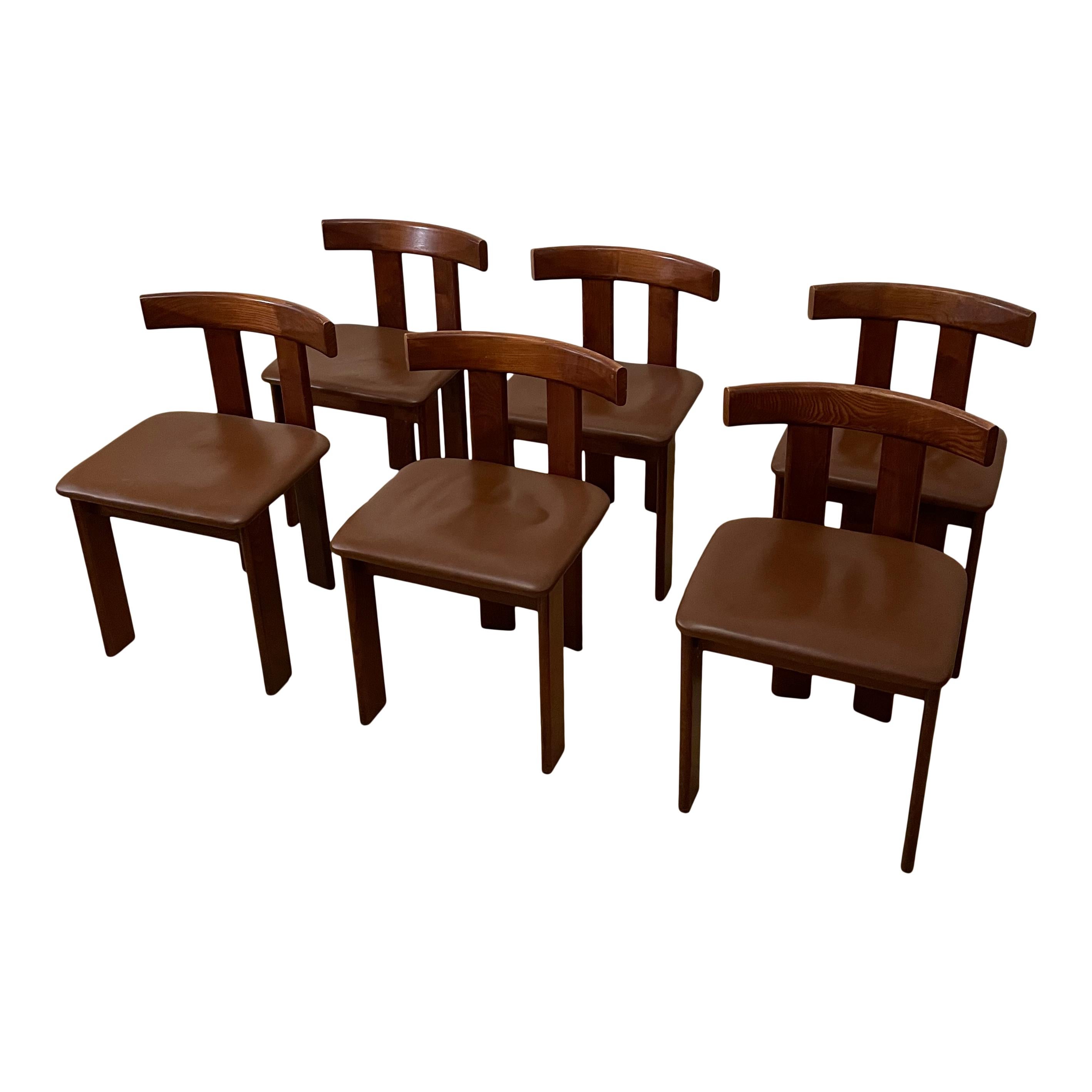 Dieses Set aus sechs Esszimmerstühlen wurde in den 1970er Jahren in Italien entworfen und hergestellt. Es zeichnet sich durch eine Struktur aus Nussbaumholz und Sitzflächen aus Leder aus. 
Diese Stühle befinden sich in einem ausgezeichneten Zustand