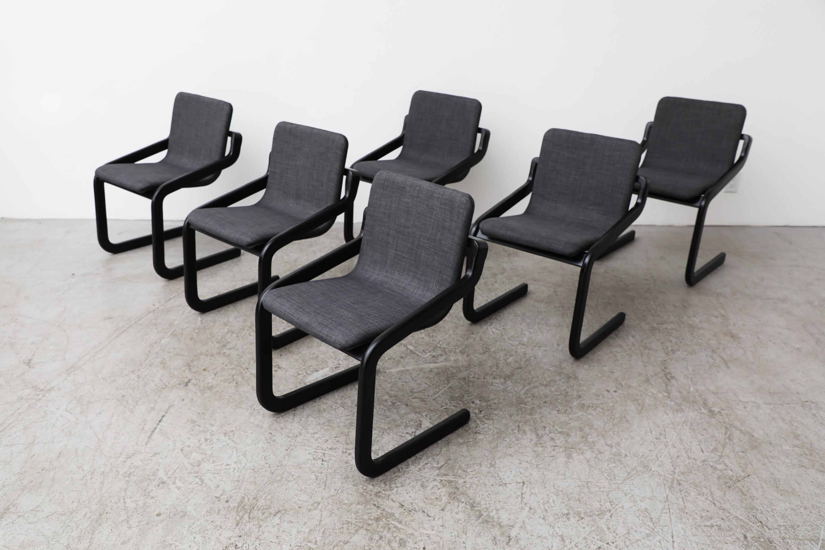 Set aus 6 Mod-Freischwingern mit schwarzem Gestell und neu gepolsterten Sitzen in Dunkelgrau. Die Sitzbreite beträgt 16,75