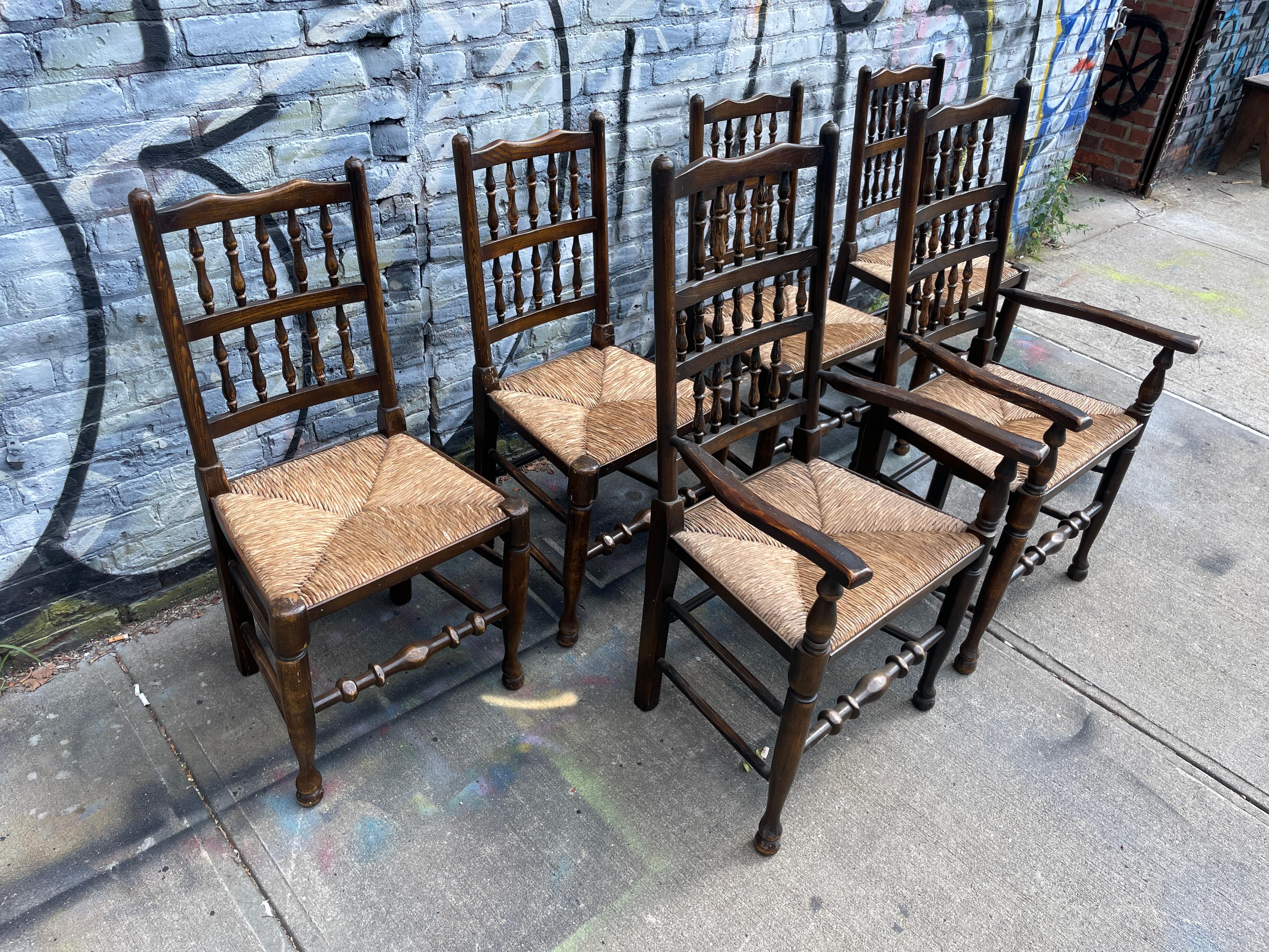 Set of 6 Modern antique style English rush dining chairs. All in good vintage condition and sturdy all rush seating is tight. Shows patina and use on frames. The 2 Arm chairs are a bit taller in height. Labeled made in England. Located in Brooklyn