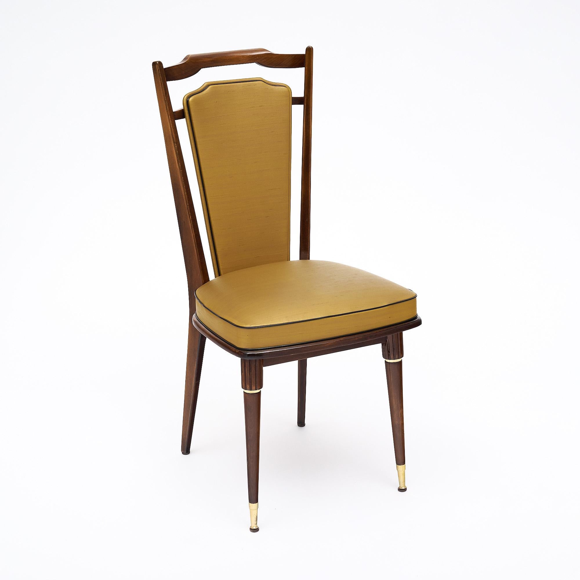 Set of six chairs in the Modernist style of Mahogany finished with a lustrous French polish. Featuring hand carved details, brass accents and brass feet. Very strong and comfortable original upholstery in vinyl blend. This set is in very nice