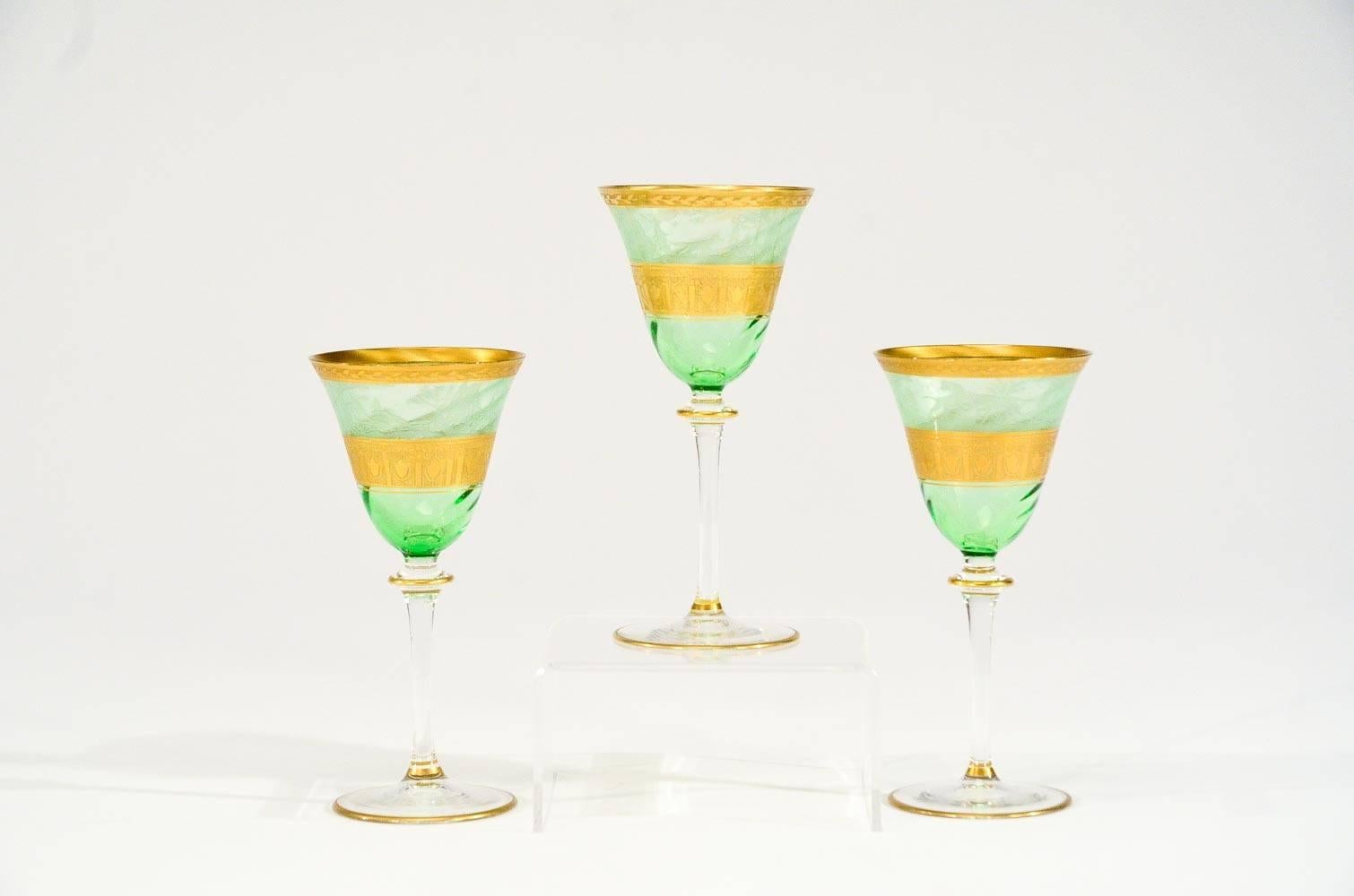 A rare and beautifully decorated set of 6 Moser hand blown goblets, perfect for your favorite dessert wine, port or cocktail. The apple green optic swirl coupe is decorated with a bands of acid etched gold and the foot is trimmed in gold,