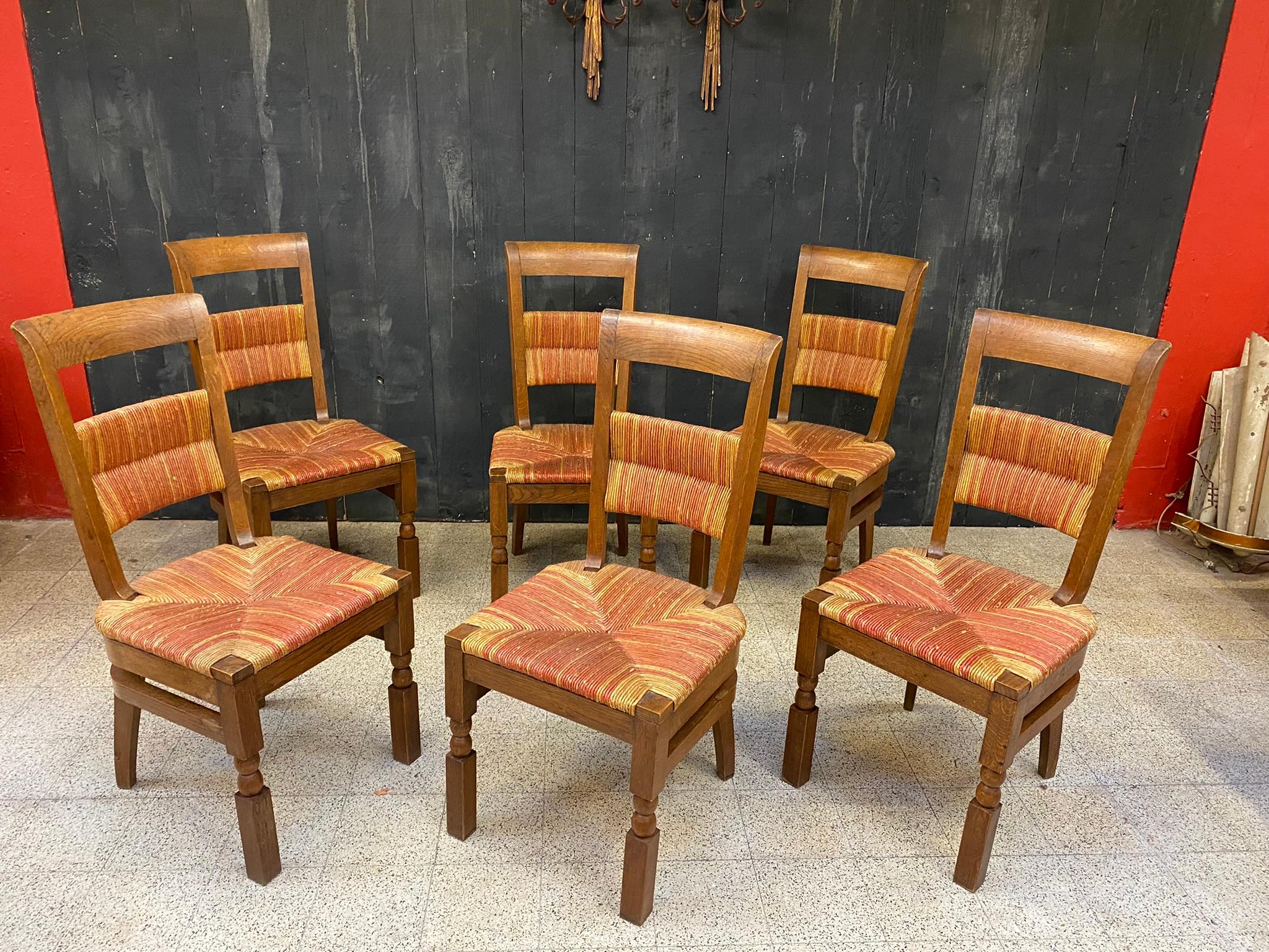 Ensemble de 6 chaises en chêne à haut dossier vers 1950, dans le style de Charles Dudouyt ou Victor Courtray 
bon état général, petites pertes superficielles sur les pailles.
 