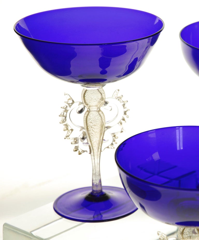 Extremely rare set of glass goblets. There are 12 and this is the listing if someone is interested in the set of 6.

The cup and foot base are in cobalt blue. This style of cup is what was considered a Champagne glass in the 50s and 60s.

There is a