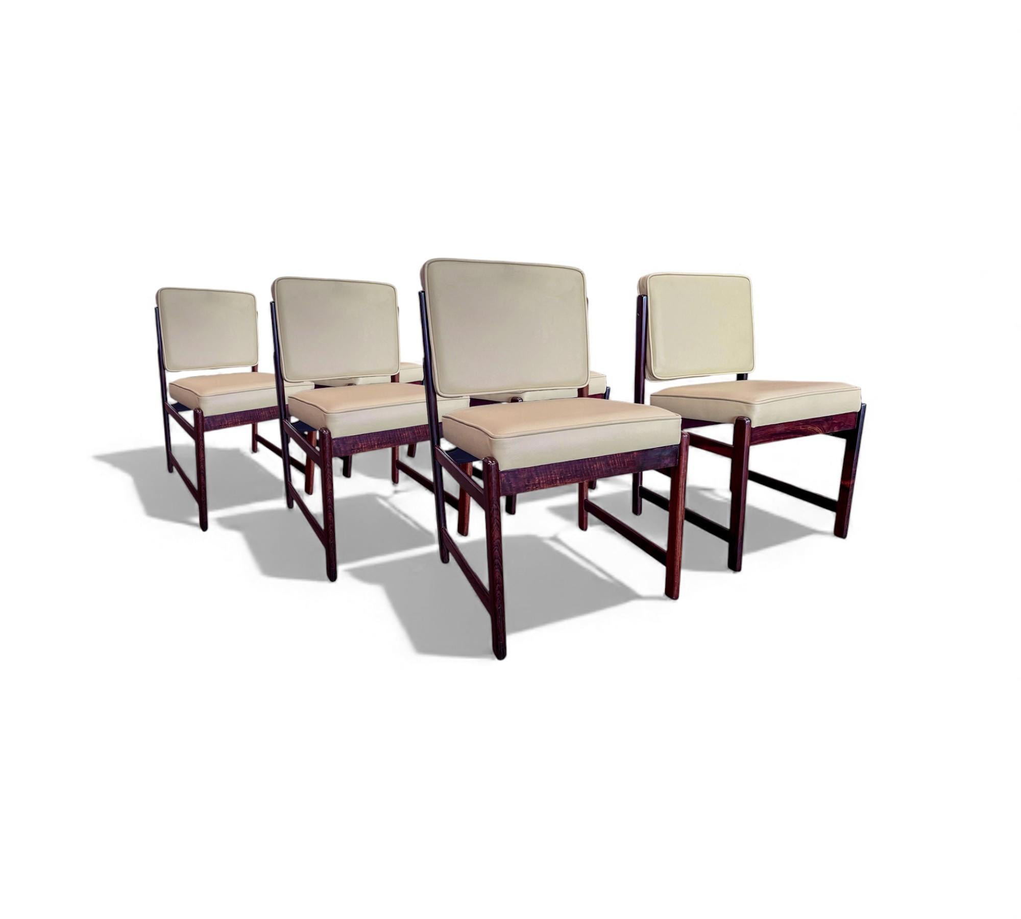 This set of six “Marco” chairs, designed by Sergio Rodrigues in the 1960s, showcases the designer’s refined approach to Brazilian modernism. Crafted from rich rosewood, the frames display clean, straightforward lines that highlight the natural