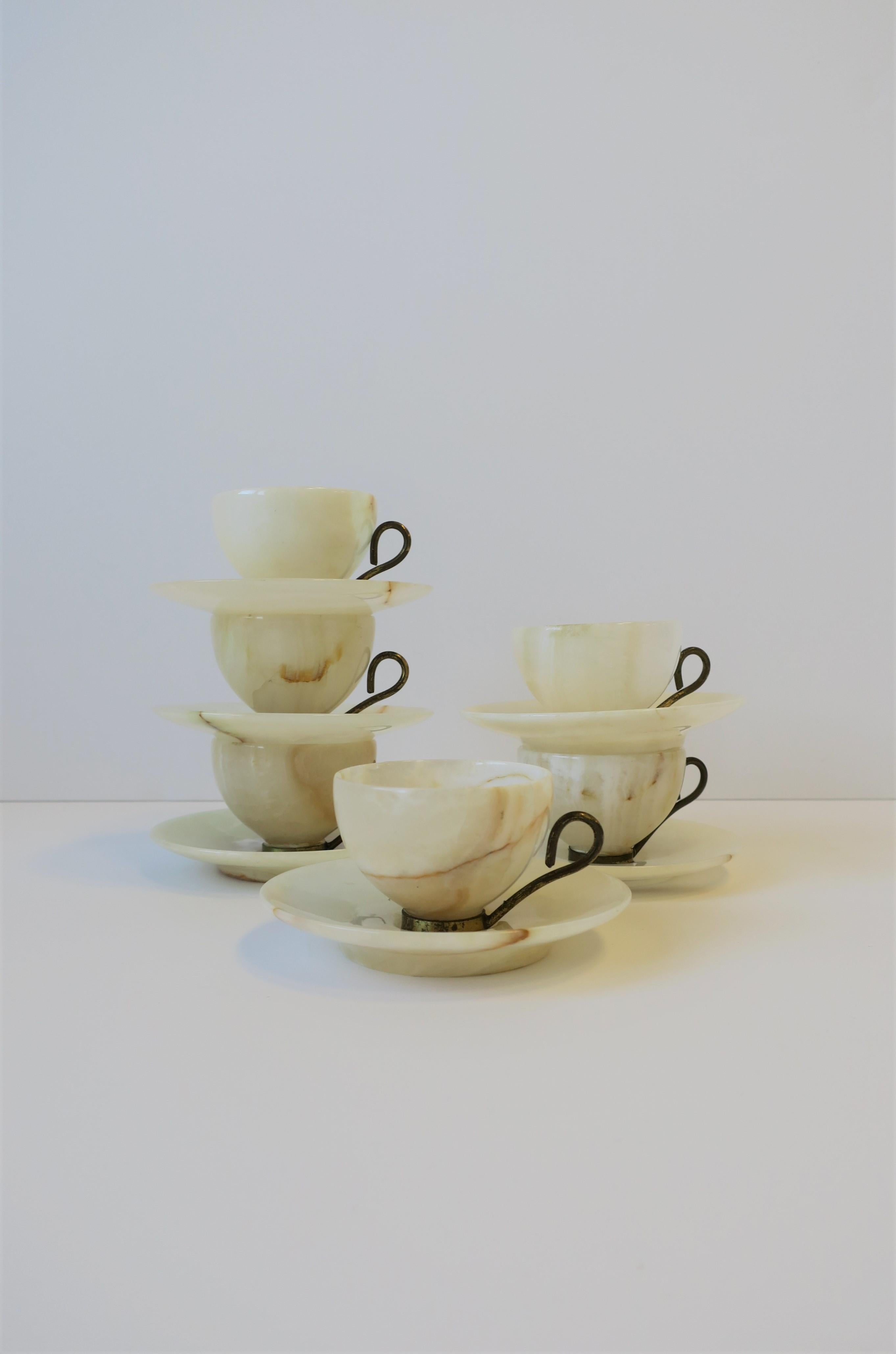 A beautiful set of six Italian onyx coffee or espresso cups and saucers with gold gilt metal handles and bases. Onyx is carved and polished smooth. Onyx hues are neutral tones; white, off-white, etc., circa 20th century, 1970s, Italy.

Measurements: