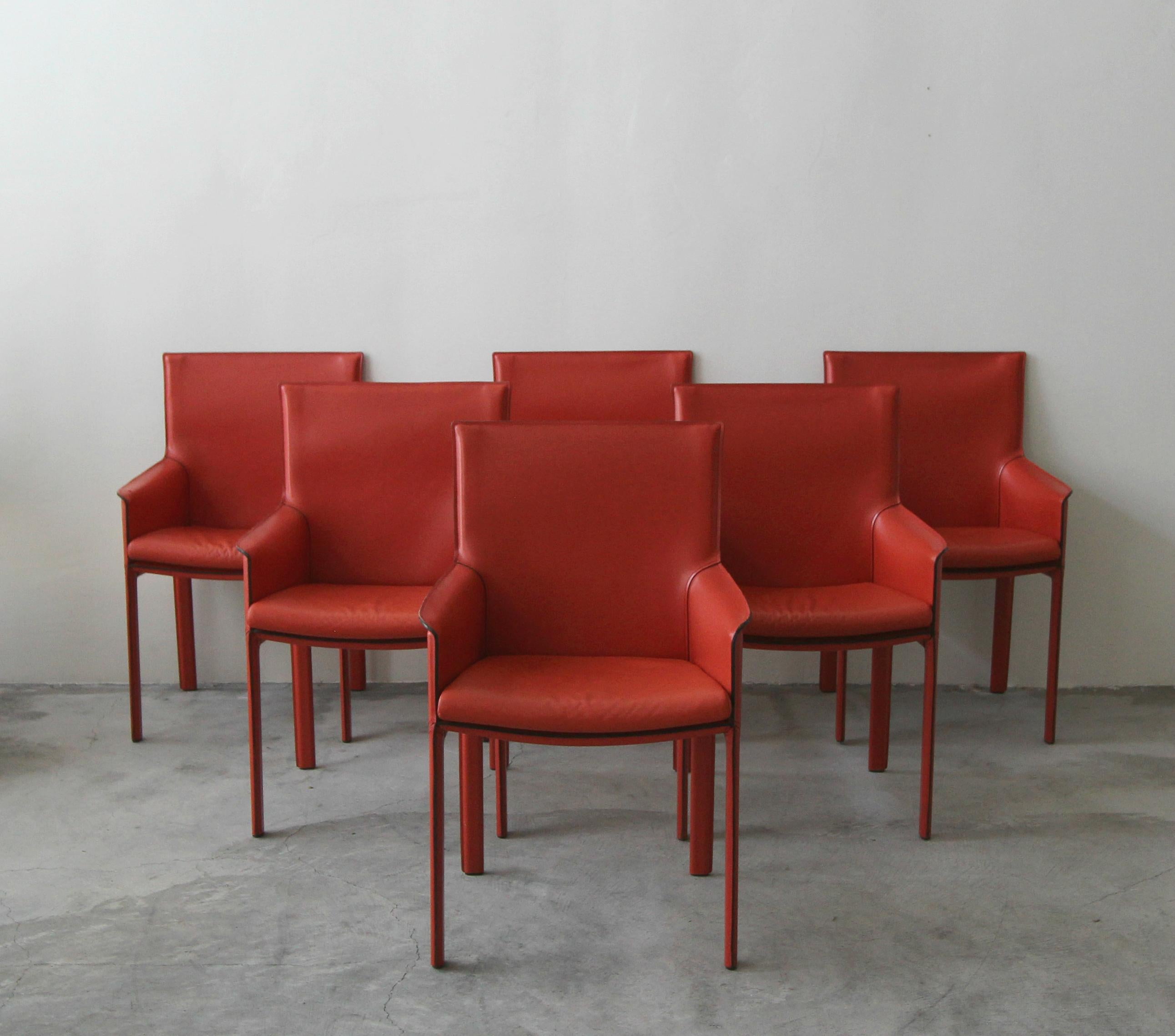 Gorgeous set of 6 Enrico Pellizzoni Pasqualina armchairs designed by Grassi & Bianchi. These chairs were custom ordered straight from Italy. They are covered in the most gorgeous shade of dark orange all grain leather. Chairs feature, rare vented