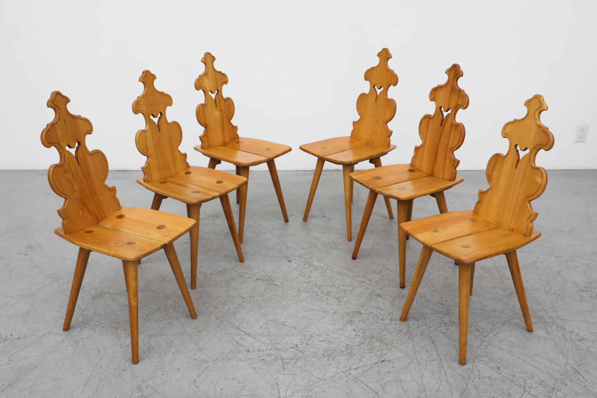 Set of 6 Brutalist Tyrolean Style blonde dining chairs with decorative hand carved backrests. In original condition with visible wear consistent with their age and use. Other set of 4 also available listed separately.