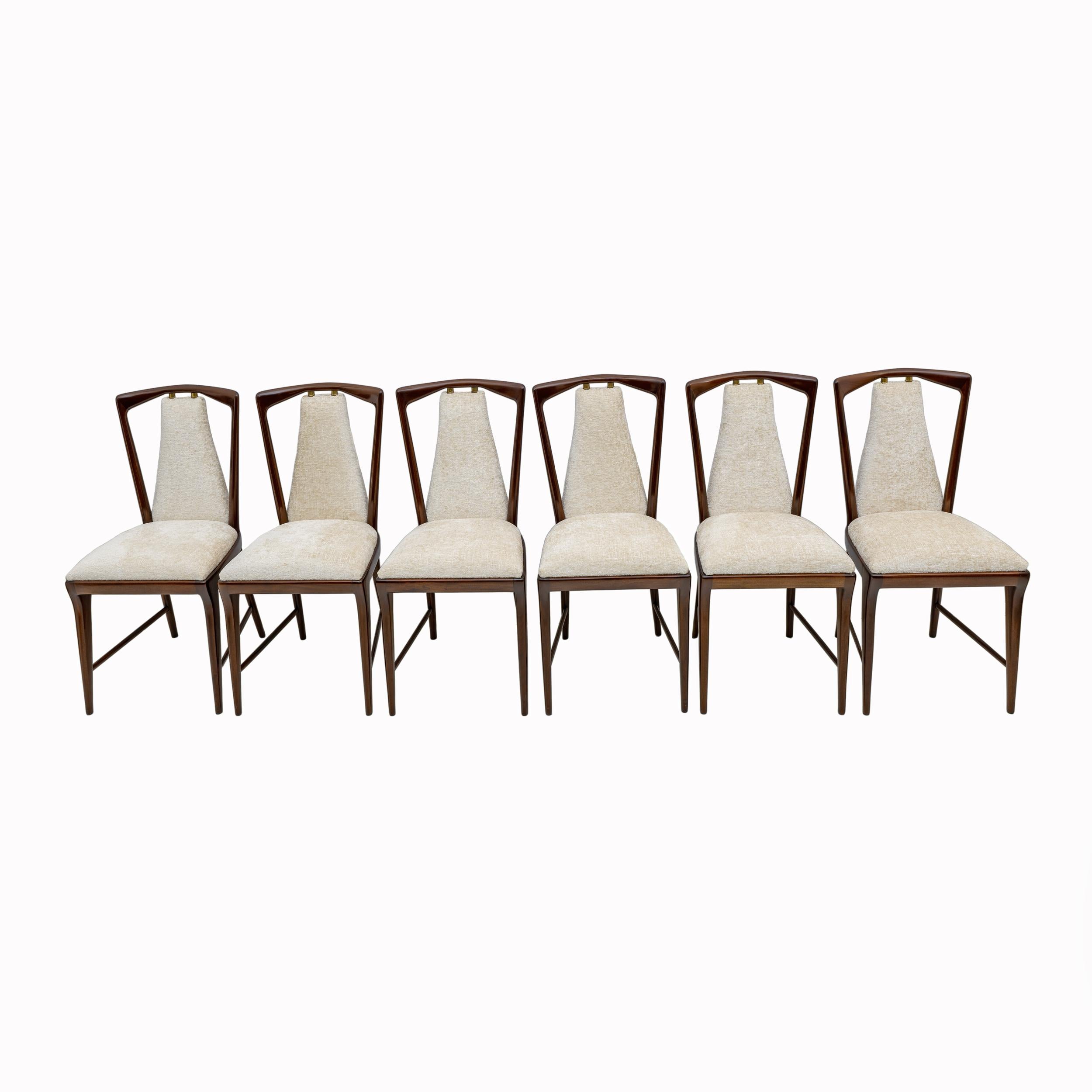 Elegant lines and solid structures for this splendid set of six dining chairs, designed by Osvaldo Borsani in the 1950s.
The wooden surfaces, as well as the backrests and seats with their padding, have been covered with Bouclè fabric and polished