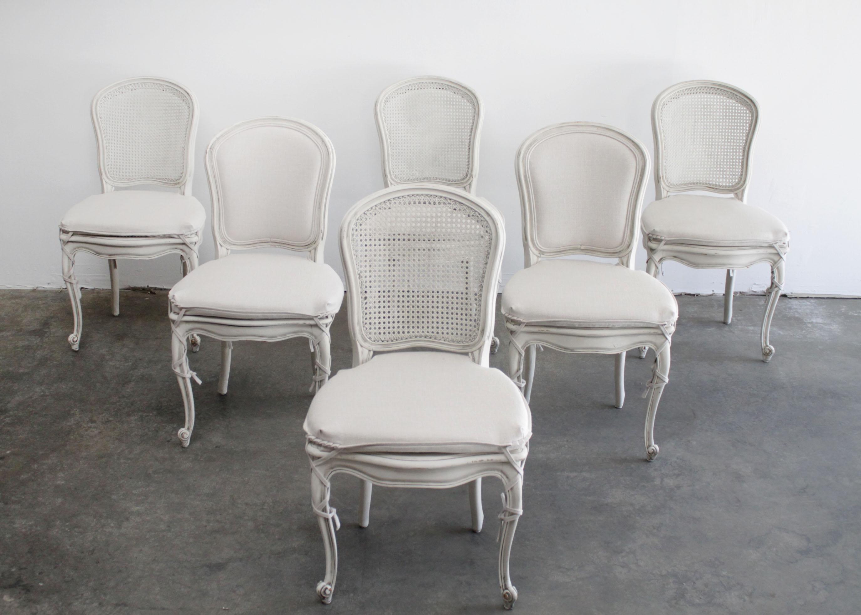 Set of 6 painted and upholstered cane back dining chairs with slip covers
Painted in our antique white finish, with subtle distressed edges, and antique
glazed patina.
This set includes 6 side chairs, 2 of them have upholstered backs, and the