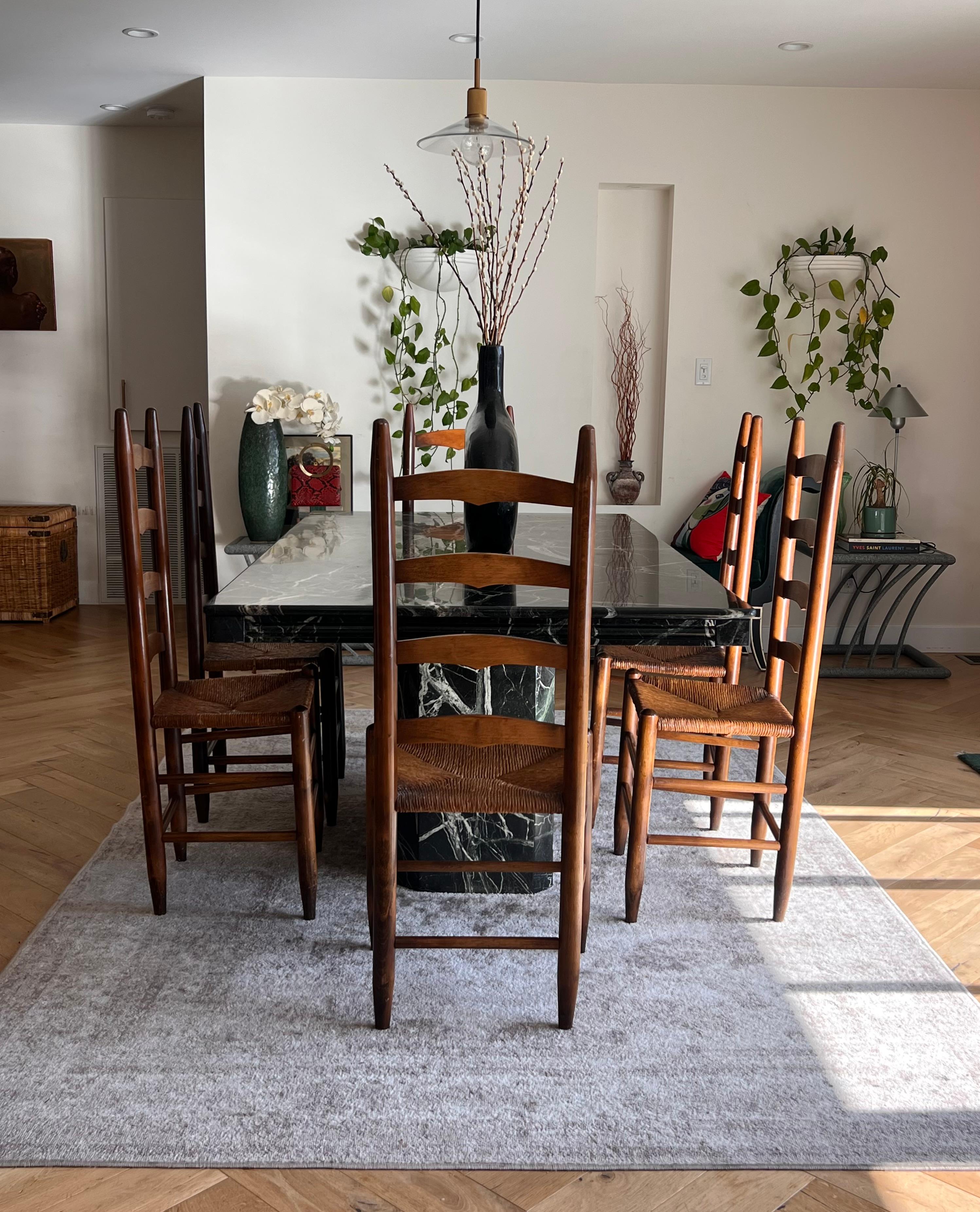 A set of six wooden dining chairs with woven wicker rush seats and ladder backs, circa early to mid 20th century. Classic in form and rustic in nature, these chairs represent the epitome of central and south European provincial, with similar style
