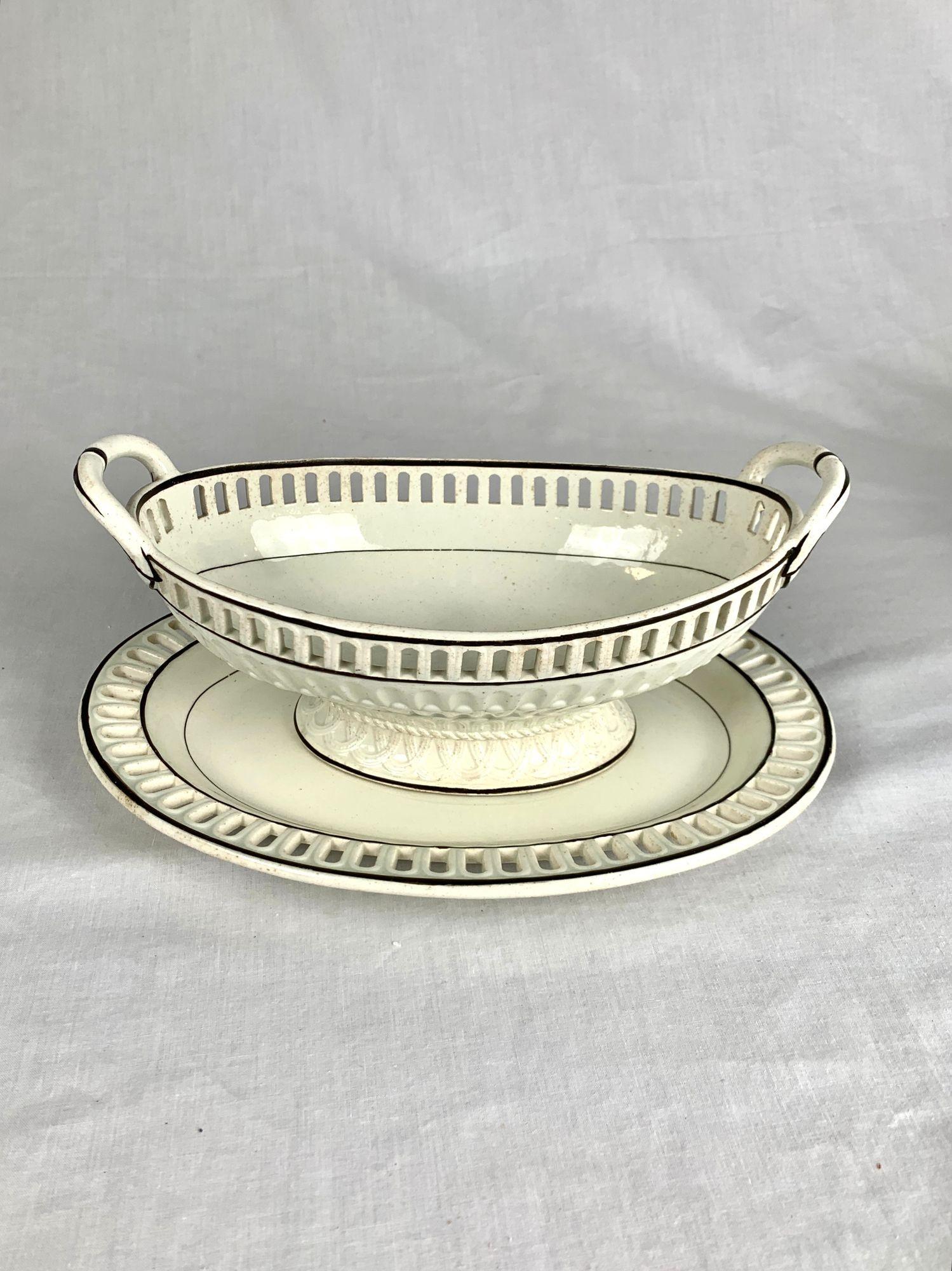 Ce rare service de six pièces de vaisselle anglaise à la crème ancienne, avec d'élégantes garnitures brunes peintes à la main, a été fabriqué entre la fin du 18e et le début du 19e siècle.
Le clou du groupe est un panier en porcelaine de Wedgwood