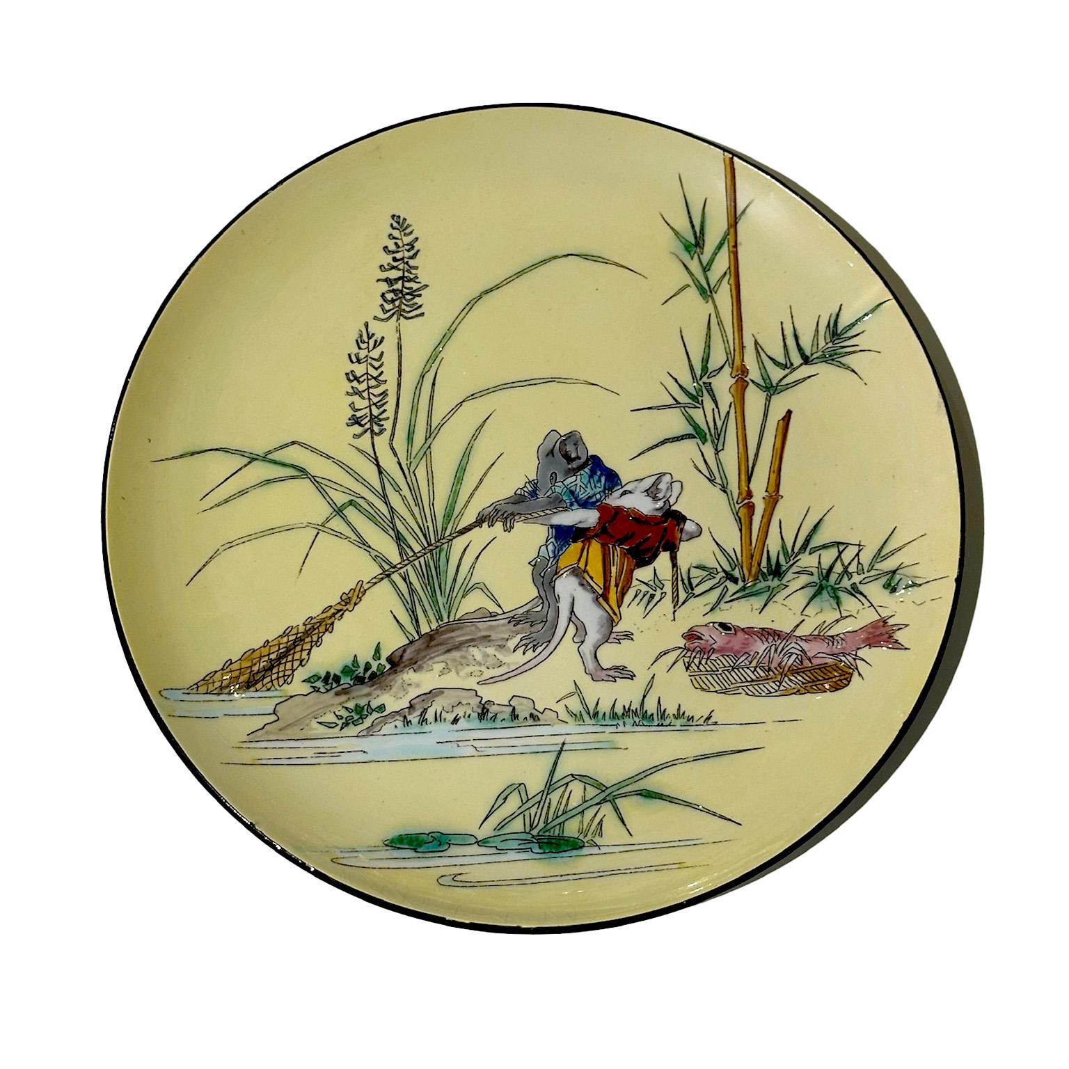 Este raro juego de platos de loza esmaltada y policromada, procedentes de la manufactura Jules Vieillard & Cie de Burdeos, presenta escenas inspiradas en el arte japonés. Diseñados por Amédée de Caranza (1843-1914), estos platos representan