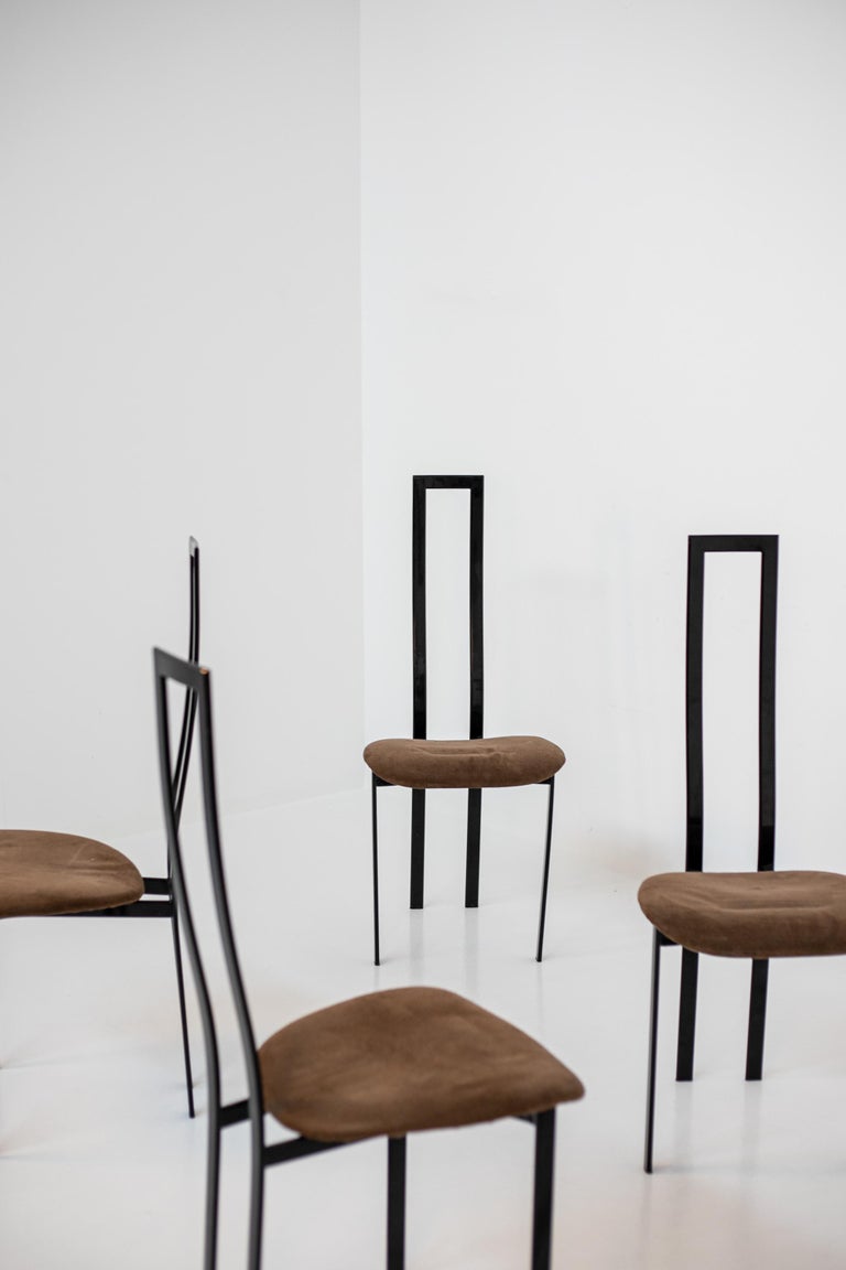 Set of six 1980s Italian postmodern dining chairs in black metal. The chairs are produced by the famous manufacture of Cattelan Italia designer Maurizio Cattelan. The chairs are made of black metal with an atropomorphic shape i.e. the backrest is