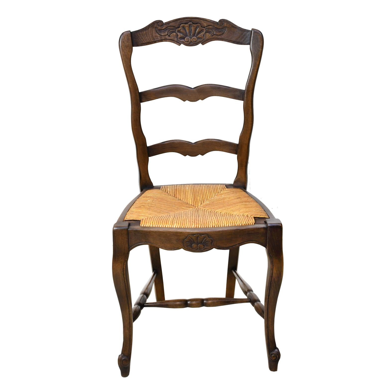 A very nice set of early 20th century French Provincial style ladder back chairs in a walnut finish with removable rush seats. All chairs are in very good condition, they have been restored and waxed. High backs are particularly