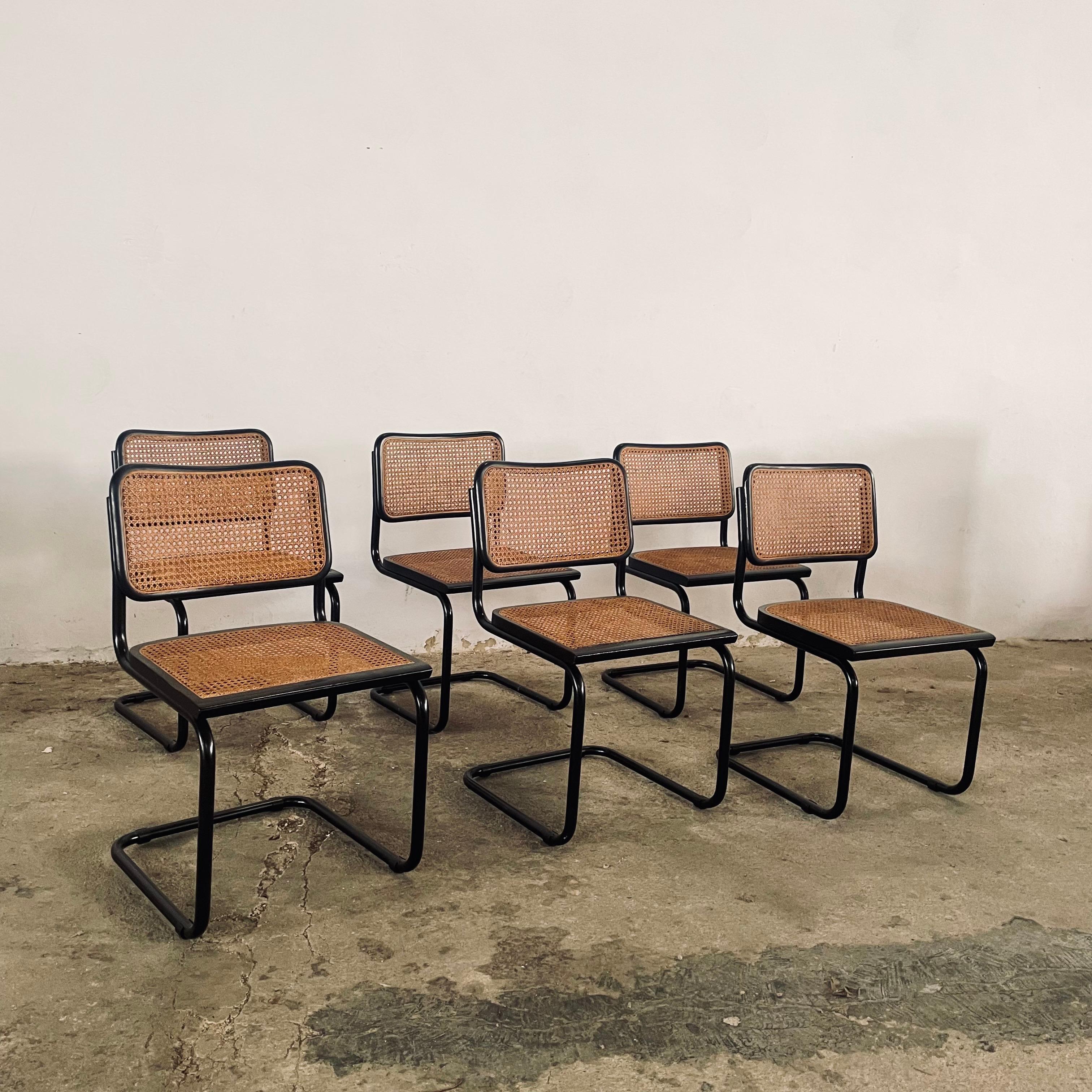Scopri un tesoro raro in questo straordinario set di sei sedie Cesca, presentate in una sofisticata esecuzione completamente nera che eleva l'iconico design di Breuer del 1928 a nuove vette di eleganza. Mentre la maggior parte delle Cesca vintage