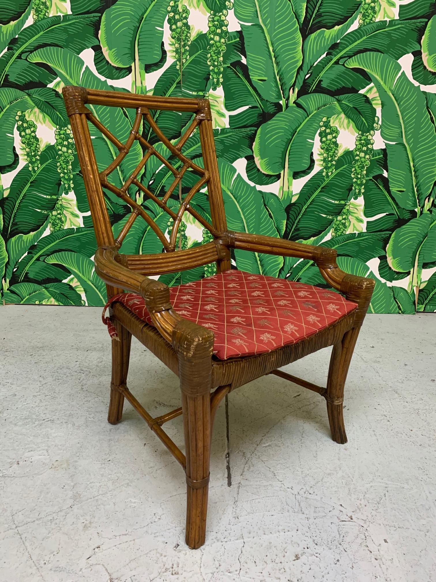 Set of 6 rattan cockpen dining chairs feature wicker seats and leather wrapped joints. Seat cushions in a deep red with palm tree design. Good condition structurally and cosmetically showing marks consistent with age and use. See photos for