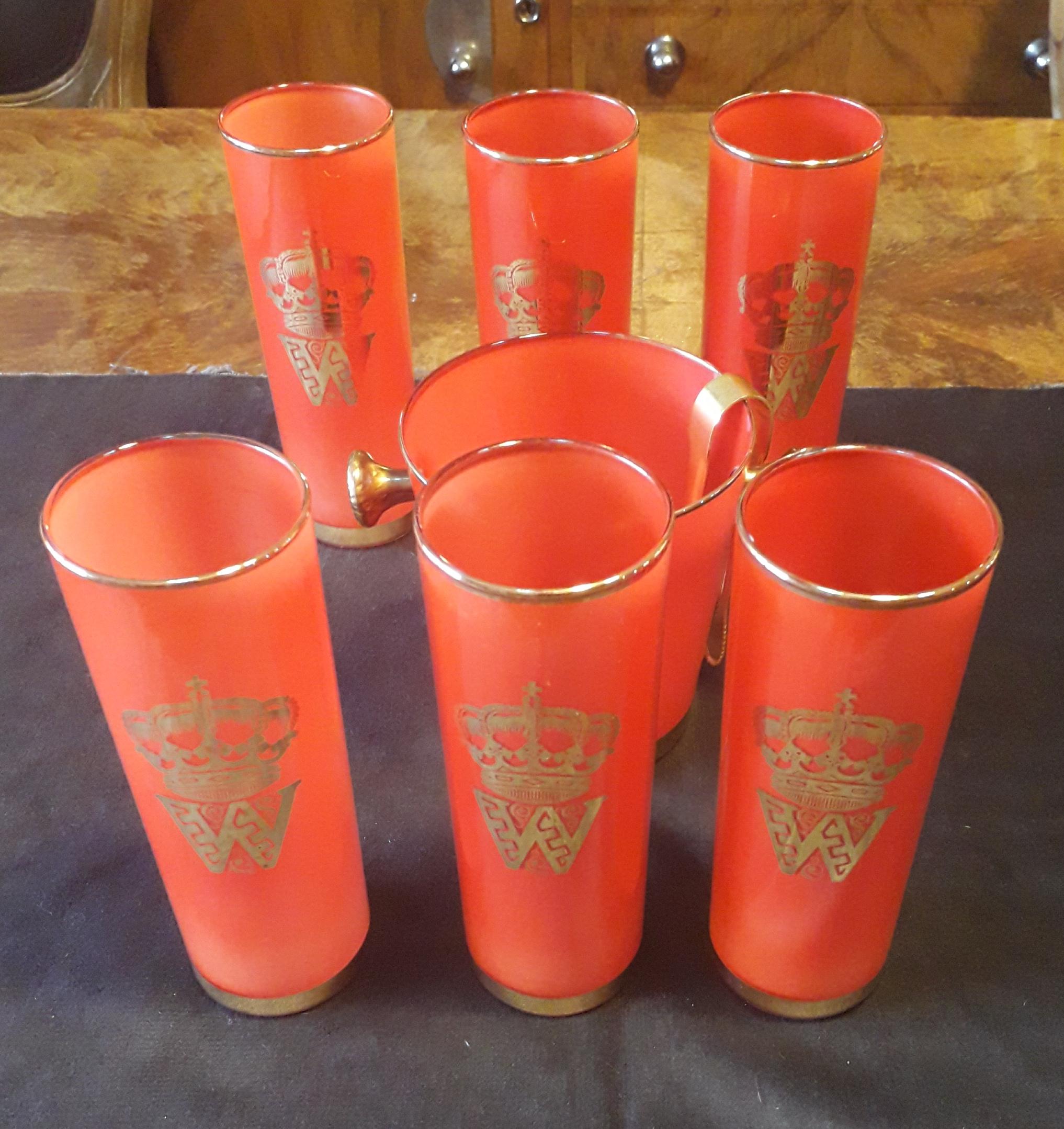 Beautiful midcentury cocktail set.

There are 6 glasses and one ice bucket, all in red colors and golden leaf.
With a gilt ice tongs
A crown in designed with the letter 