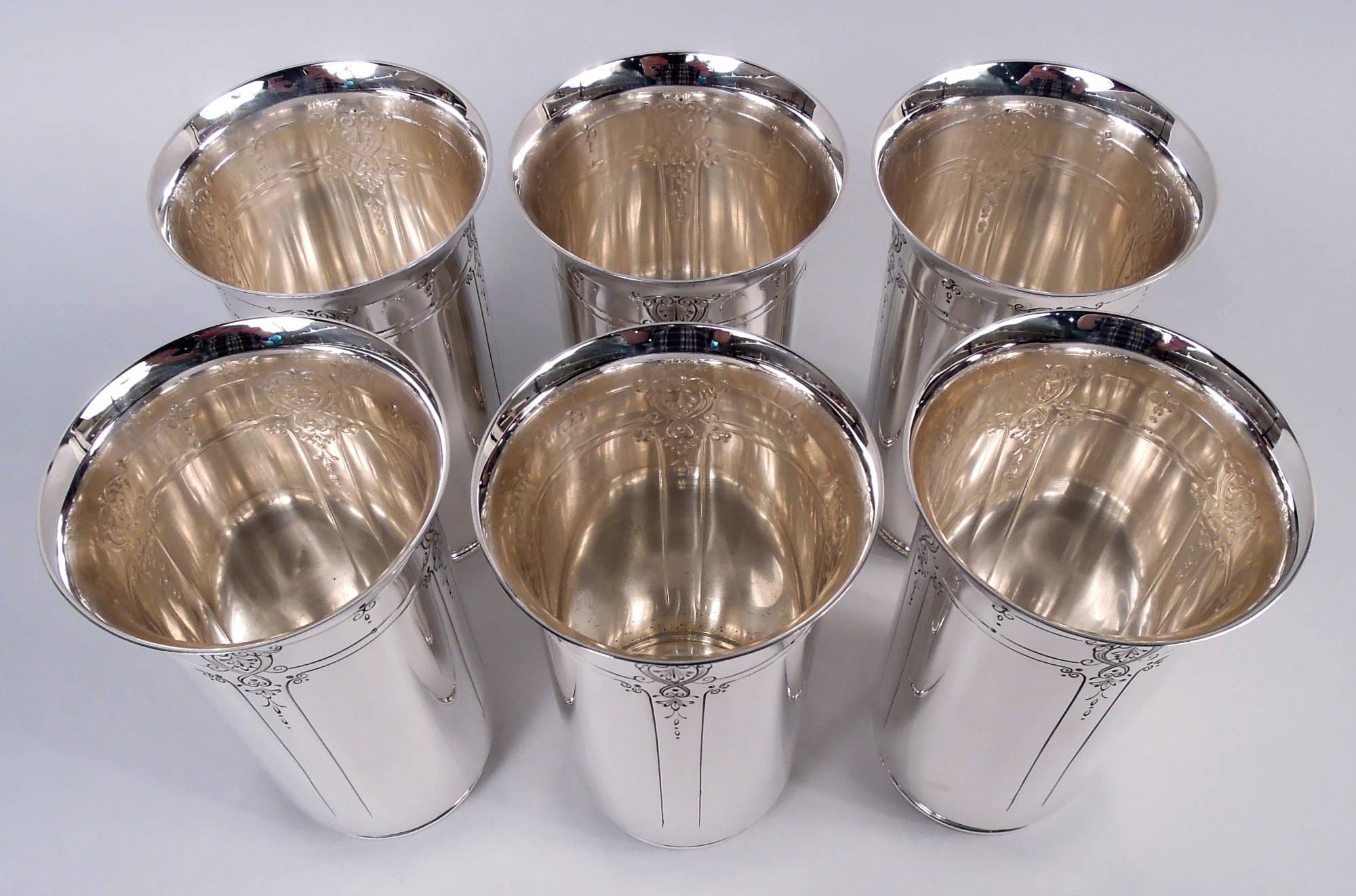 Set of 6 Edwardian Regency sterling silver highballs. Made by Reed & Barton in Taunton, Mass., ca 1910. Each: Cylindrical with flared rim and short foot. Chased scroll and leaf ornament with pendant flowers and rectilinear frames. Fully marked