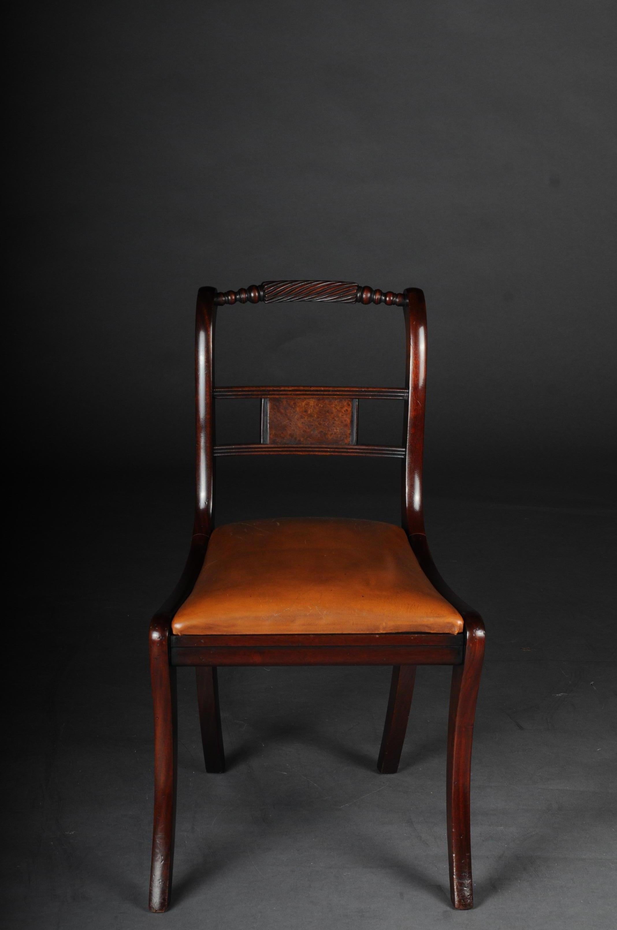Set of 6 Regency English chairs or armchairs, 20th century

Solid mahogany wood. England Regency 20th century. Curved and partly turned backrest.
Leather-covered seat on saber-shaped legs. Set of 6 chairs including 2 armchairs.
(C-163).