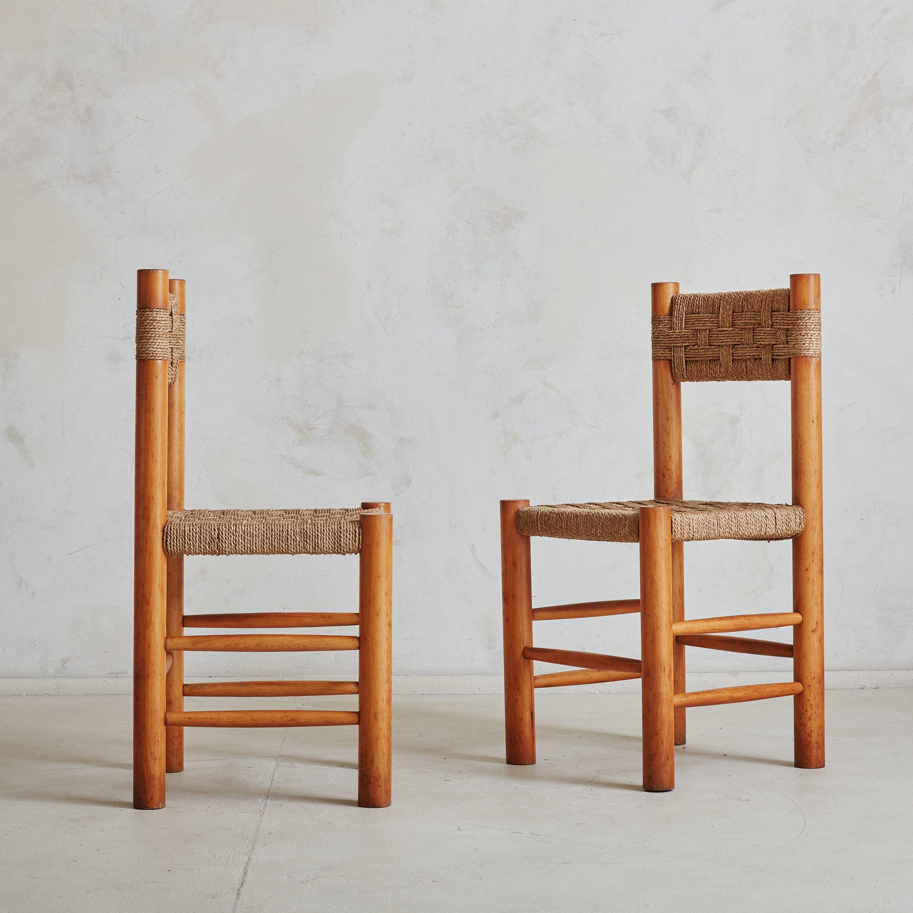 A set of 6 beautifully crafted wood and rush dining chairs, reminiscent of Charlotte Perriand and her infamous Dordogne chair for Robert Sentou. These chairs feature solid beech wood frames in a warm, honey hue, with rush seats and backs woven in a