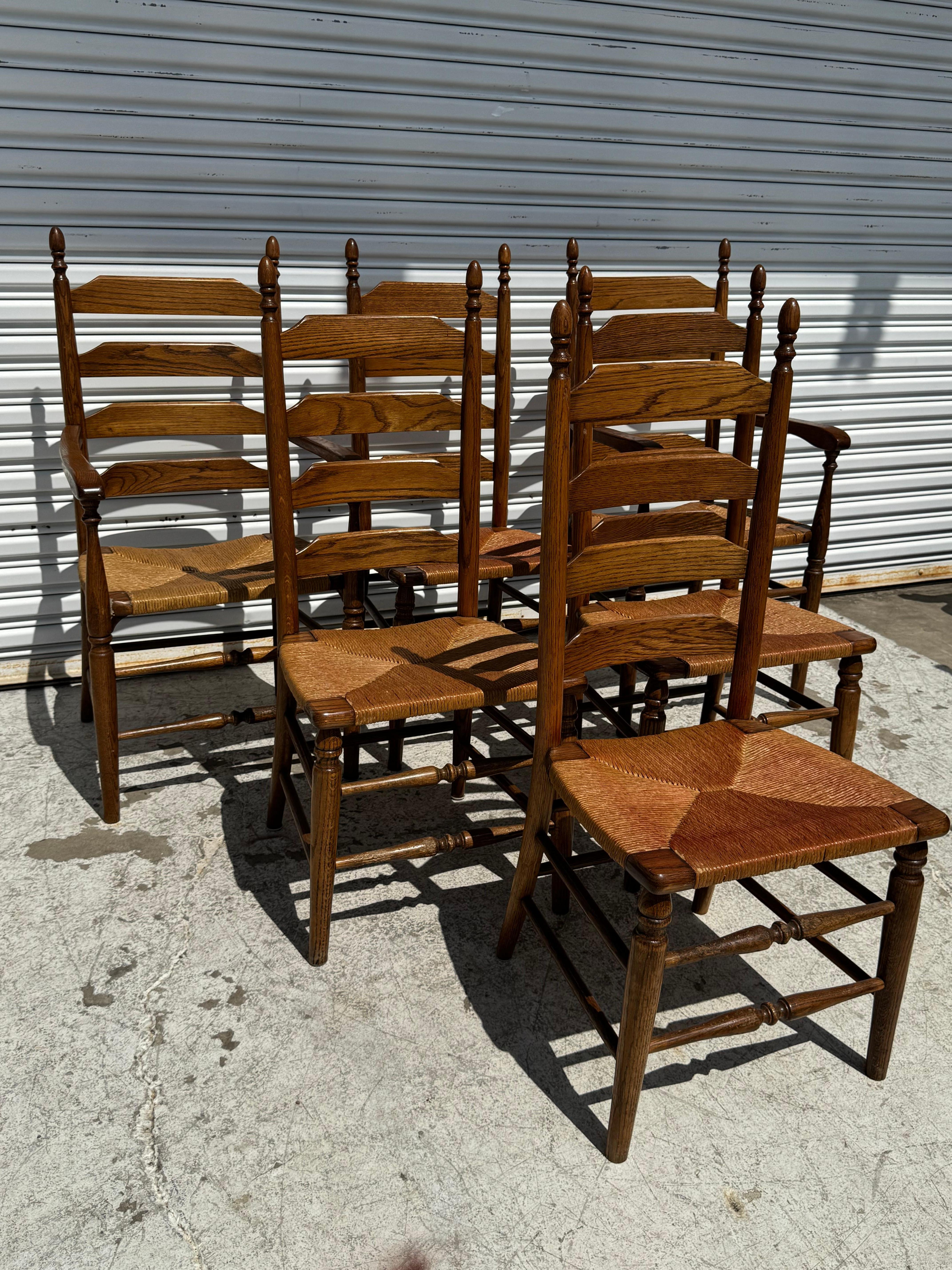 This set of ladderbacks are made of walnut and have rush bottom seats.
They have turned legs and stretchers the reinforce the chairs stability. 
There are 2 armchairs and 4 sides.