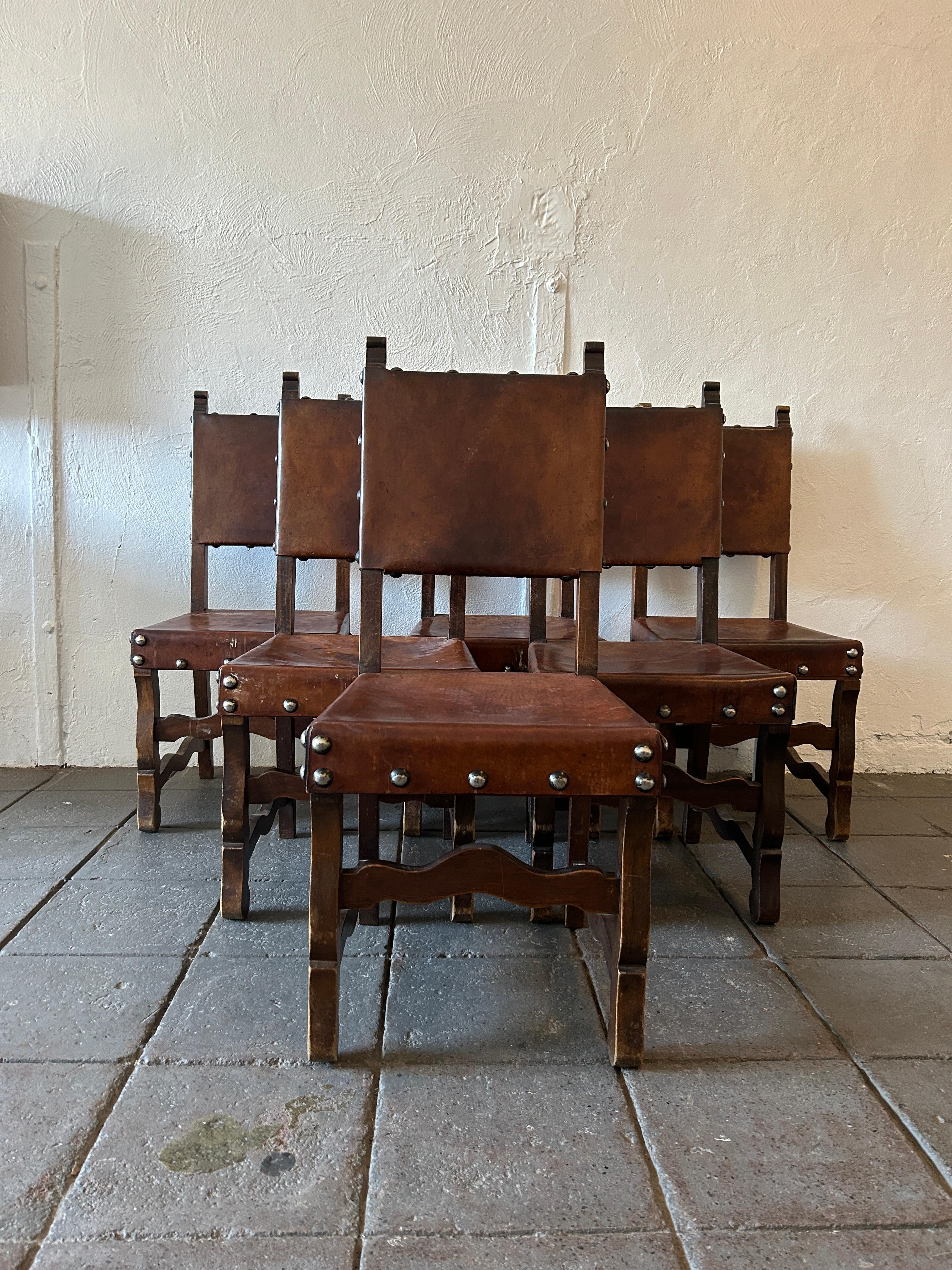 A set of ‘6’ rustic Spanish sling chairs leather & Elm wood, classic structure in the rustic carved style, original leather with lots of discolorations and patina but overall in very nice shape. All structural with tight leather backs and seats just