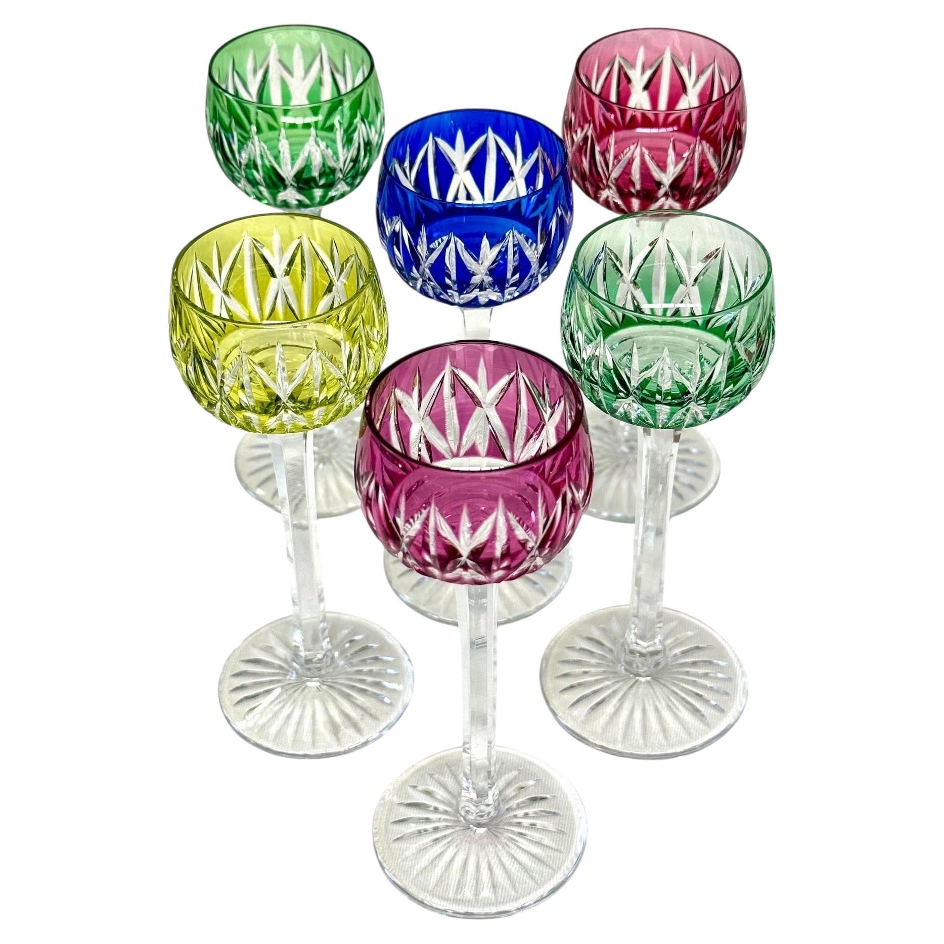 Un magnifico set di sei bicchieri da liquore in cristallo Saint Louis, ciascuno finemente tagliato a mano e sovrapposto a cristalli dai colori vivaci nelle tonalità del verde smeraldo, rosso rubino, blu zaffiro, giallo ambra e rosa ametista.