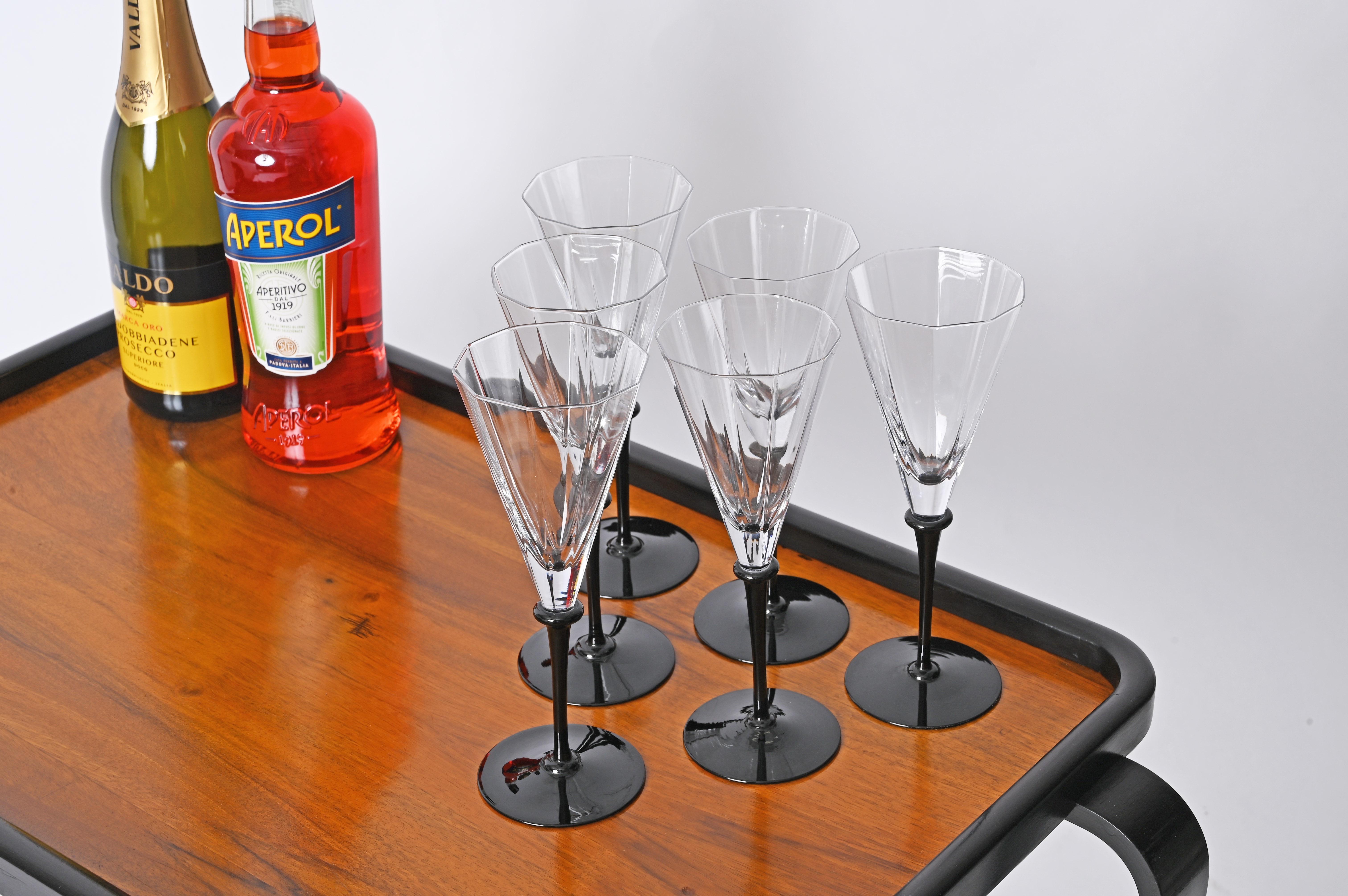 Stunning set of six signed Cartier champagne flutes in a gorgeous mix of black and clear crystal.

This marvelous multifaceted glasses are made in a French crystal of outstanding quality. The sinuous design and the contrast between the deep black