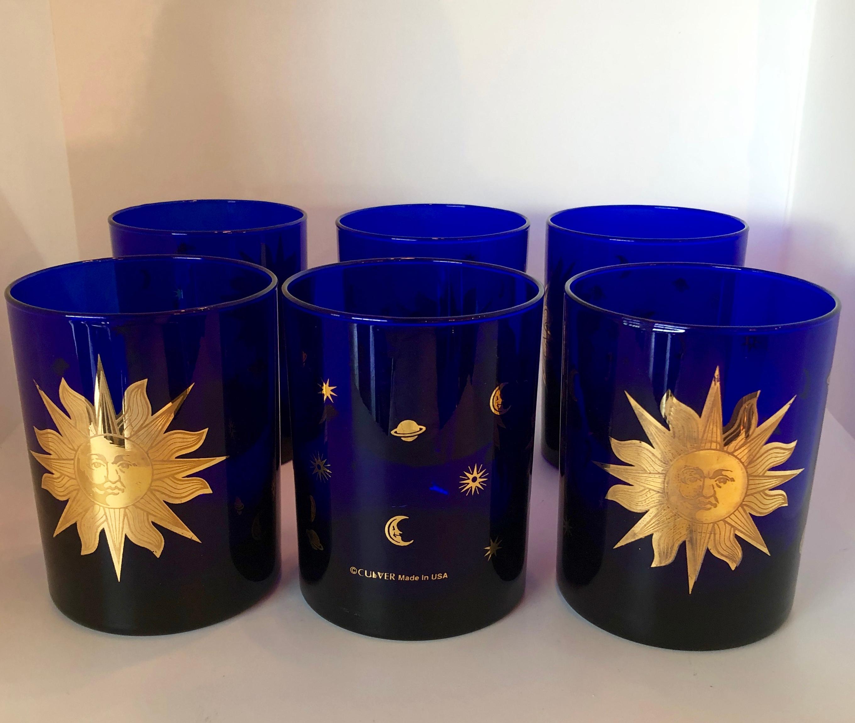 Offered is a set of signed Culver Mid-Century Modern deep cobalt blue double old fashioned cocktail glasses featuring 22-carat gold decoration of a large celestial sun to the front and smaller moons, stars and planets to the backs. Each of these