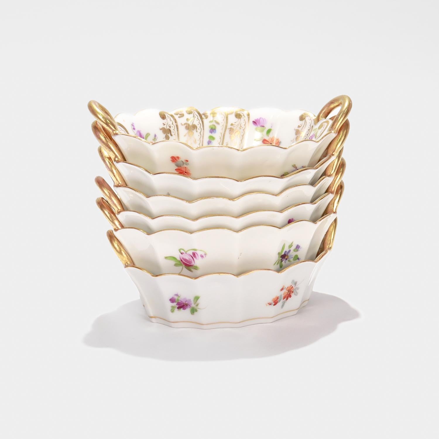 A fine set of 6 small Dresden porcelain twin-handled bowls.

By Richard Klemm.

Perfect for use as condiment or pickle dishes. 

With a tapered, shaped body, a scalloped rim, and twin handles.

Decorated with typical Dresden polychrome painted