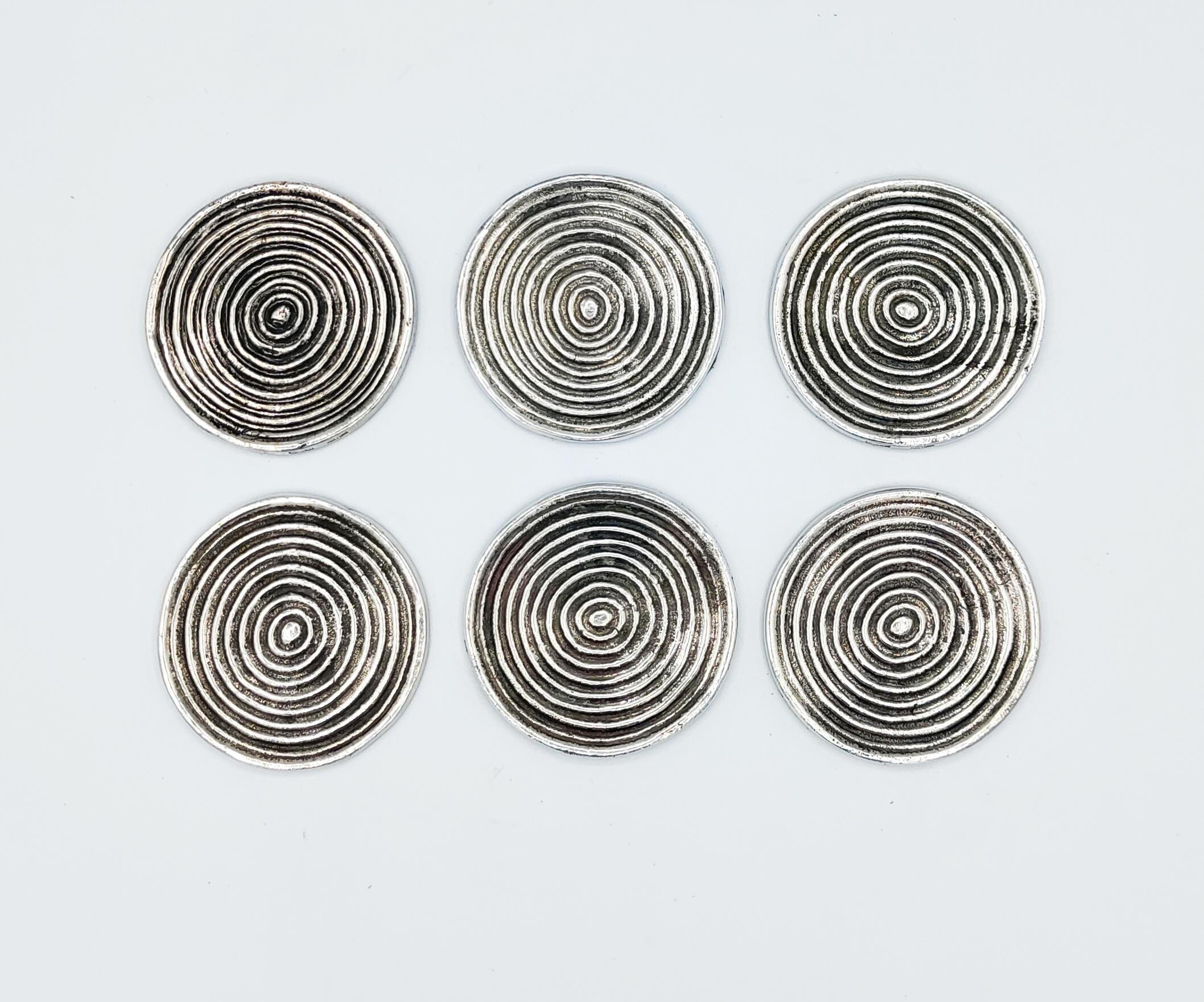 Beautiful and rare set of 6 silver metal coasters manufactured by Valenti in Spain in 1970s. Incredible work of quality with a heavy silver metal with a spiral screw , and on the over size a beautiful brown leather.
