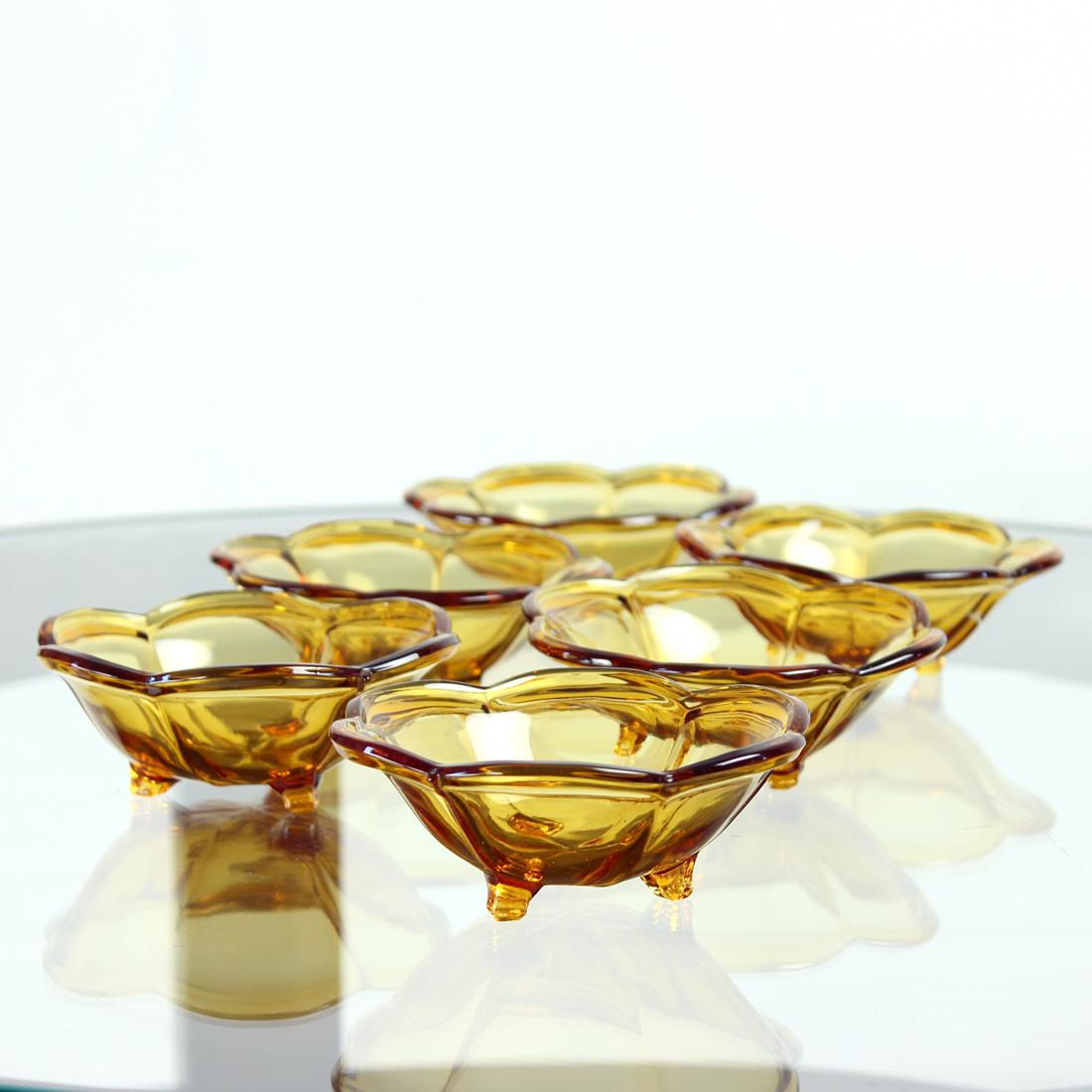 Ensemble de 6 bols produits dans les années 1960 par l'usine tchécoslovaque Borske SkLO Glass Union, dans le cadre du design moderne du milieu du siècle dernier. Le modèle figure dans un catalogue officiel. Fabriqué en verre pressé de couleur ambre.