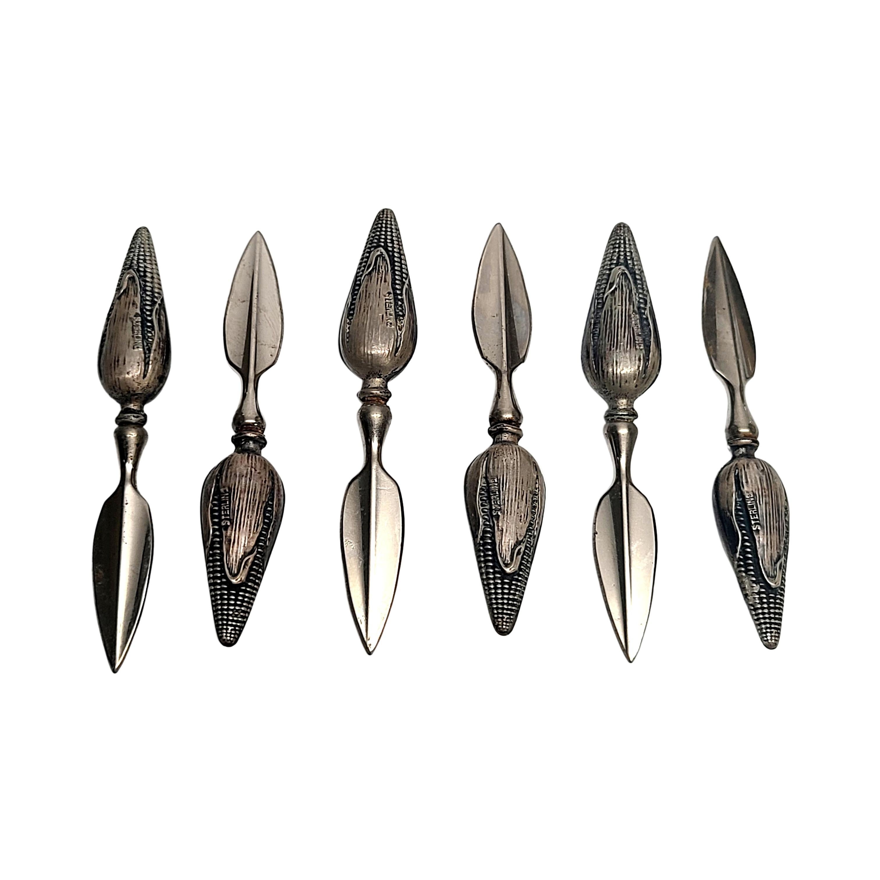 Set of 6 vintage sterling silver corn cob holders.

6 highly detailed corn cobs atop a spoke to hold corn on the cob.

Measures approx 3 1/8