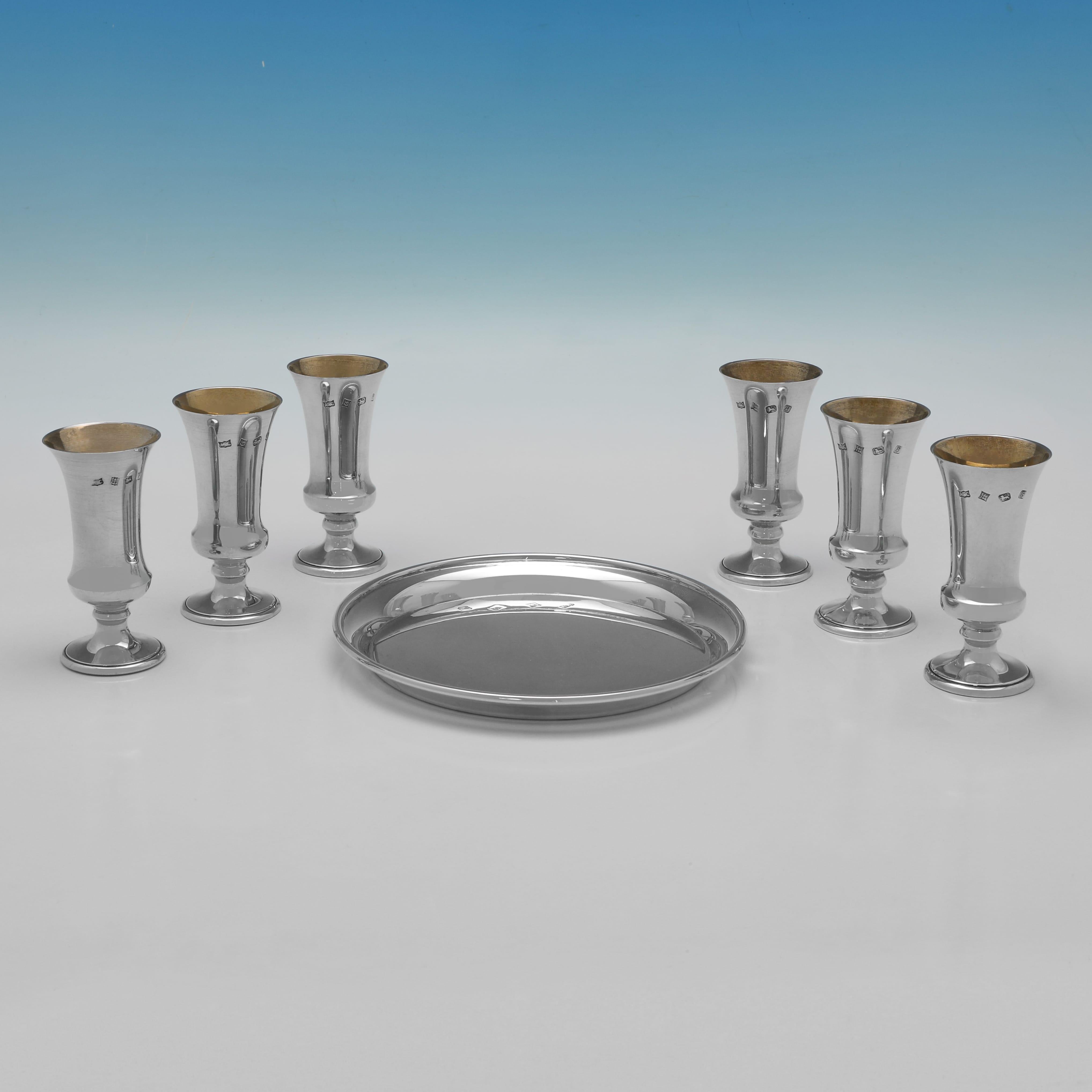 Marchiato a Birmingham nel 1976 da A. T. Cannon Ltd e a Birmingham nel 1986 da T.E. Porter, questo affascinante set di 6 tazze da kiddush in argento Sterling Elisabetta II su vassoio ha un design semplice, con gli interni dorati delle tazze da