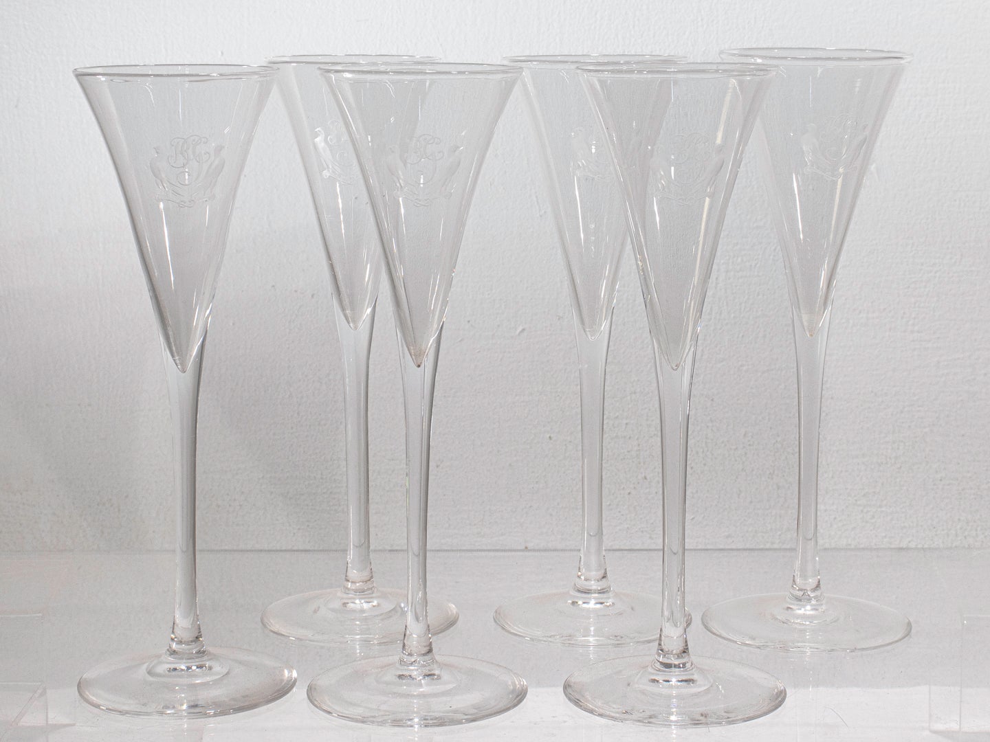 A fine set of 6 crystal glass champagne flutes or stems.

By Steuben.

With a pair of wheel-cut birds flanking a cursive monogram that reads 