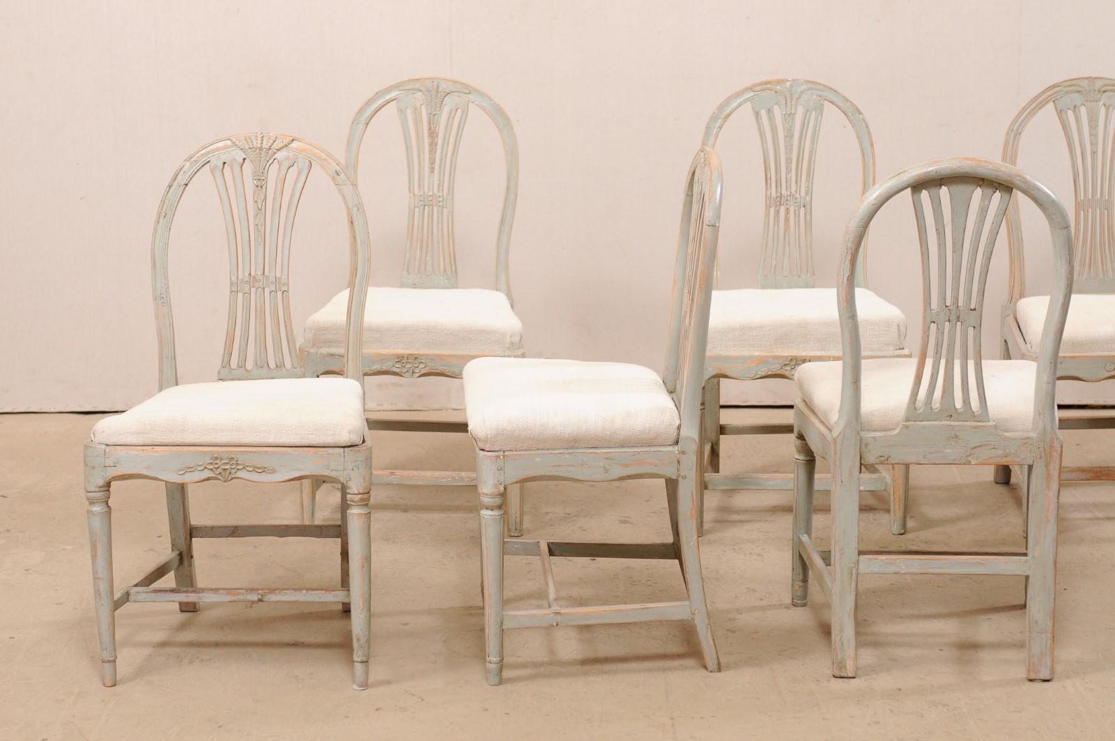 A Swedish set of six Provincial Gustavian wheat back side chairs from the early 19th century. These antique chairs from Sweden each feature nicely curved top rails with wheat-carved, pierced-splat backs, and gracefully scalloped skirts with a sweet