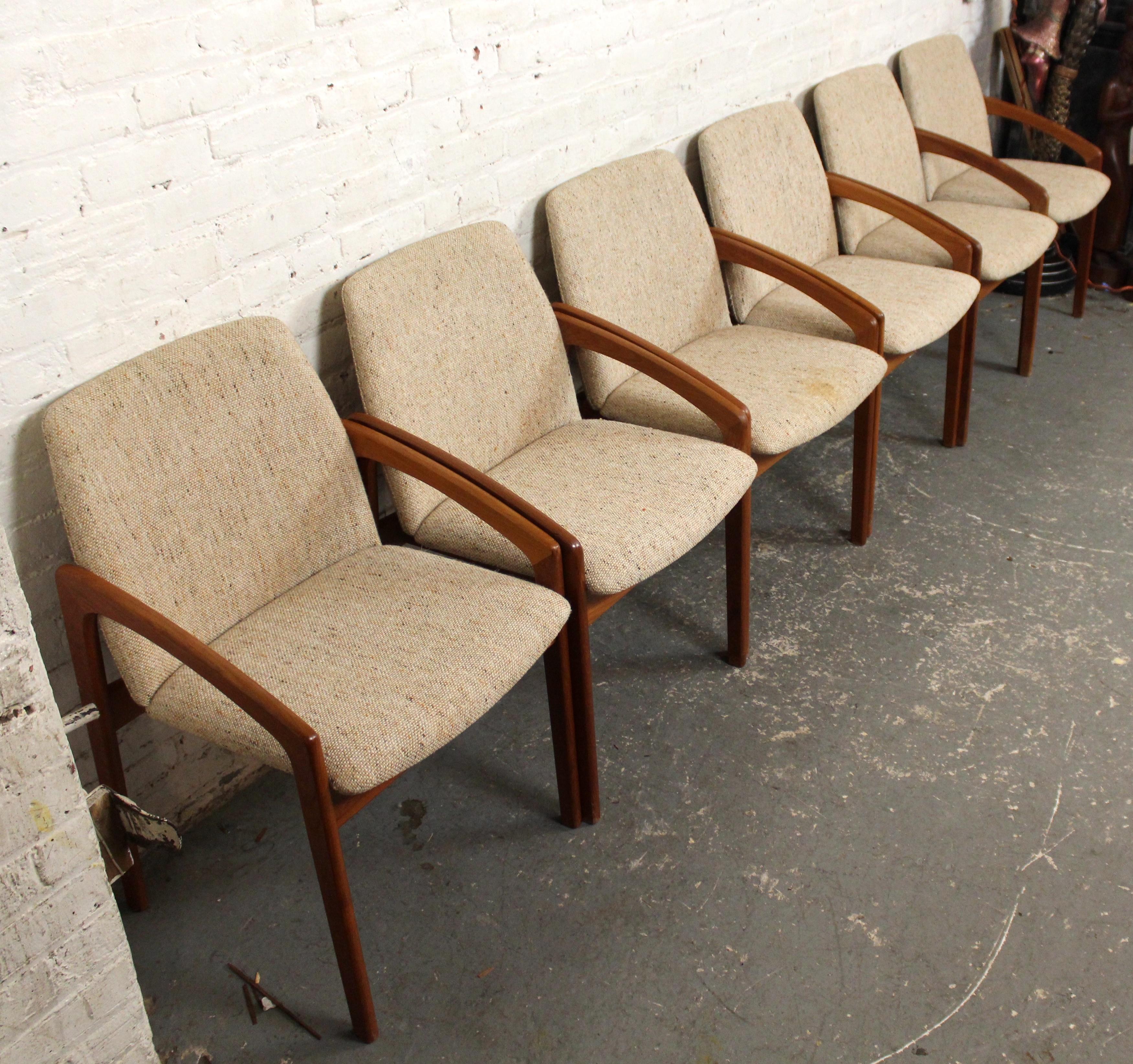 Ensemble de 6 chaises de salle à manger en teck de fabrication danoise avec des cadres enveloppants. Coussins souples sur l'assise et le dossier, accoudoirs inclinés pour plus de confort et possibilité de glisser chaque chaise sous la