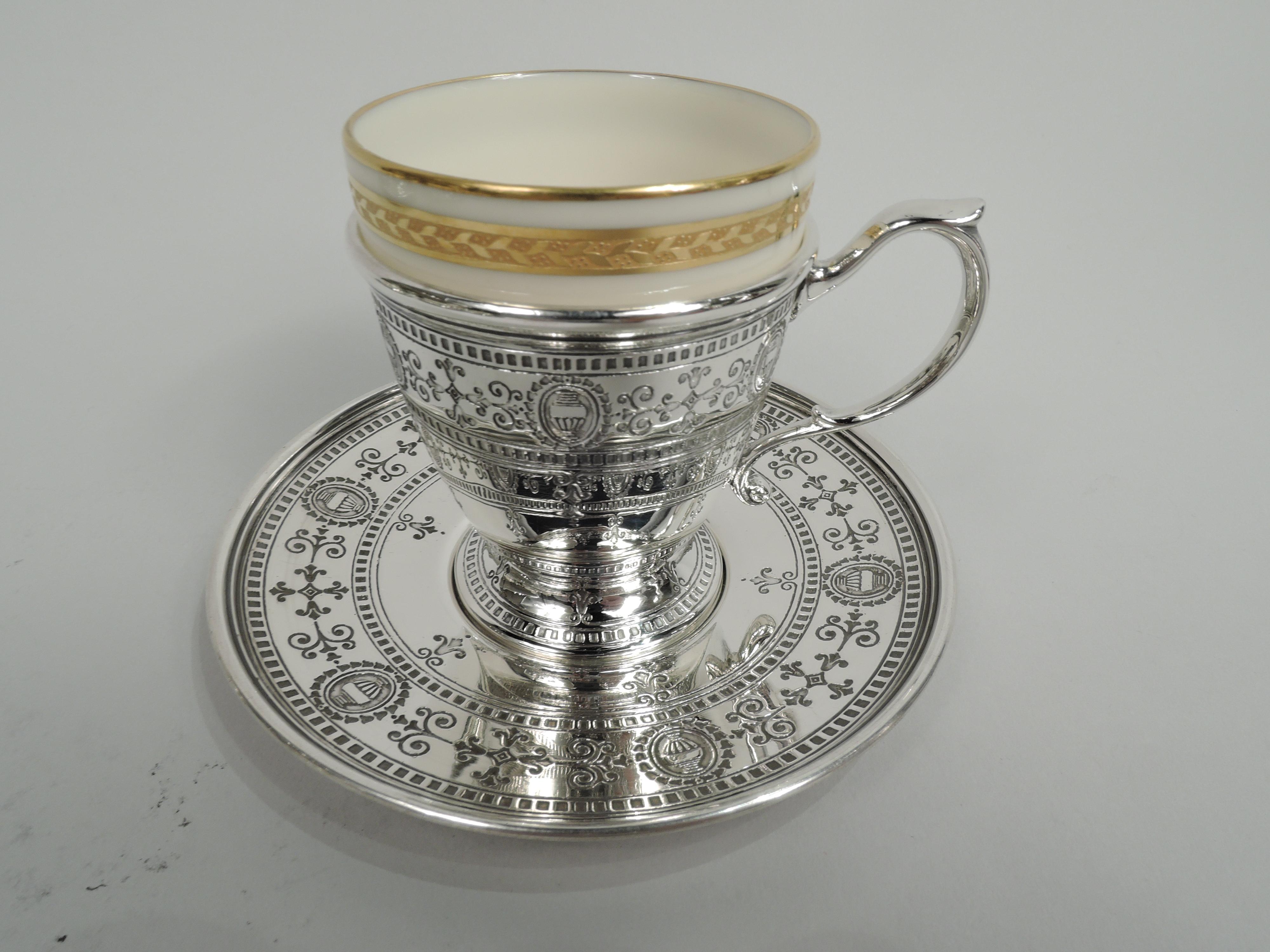 Set of 6 Edwardian Regency sterling silver demitasse holders and saucers. Made by Tiffany & Co. in New York, ca 1914. Each holder: Tapering bowl with open bottom, high-looping capped handle, and raised and spread foot. Each saucer: Round with well