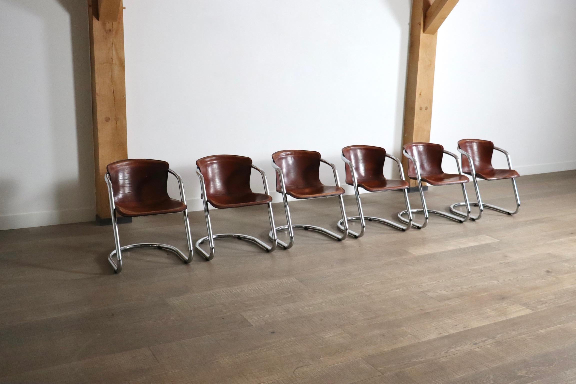 Amazing set of 6 dining chairs with a chrome tubular frame with brown saddle leather for Metaform, 1970s.

The chairs are very similar to the designs of Willy Rizzo, The tubular chrome frame and thick leather seating combine very well in this nice