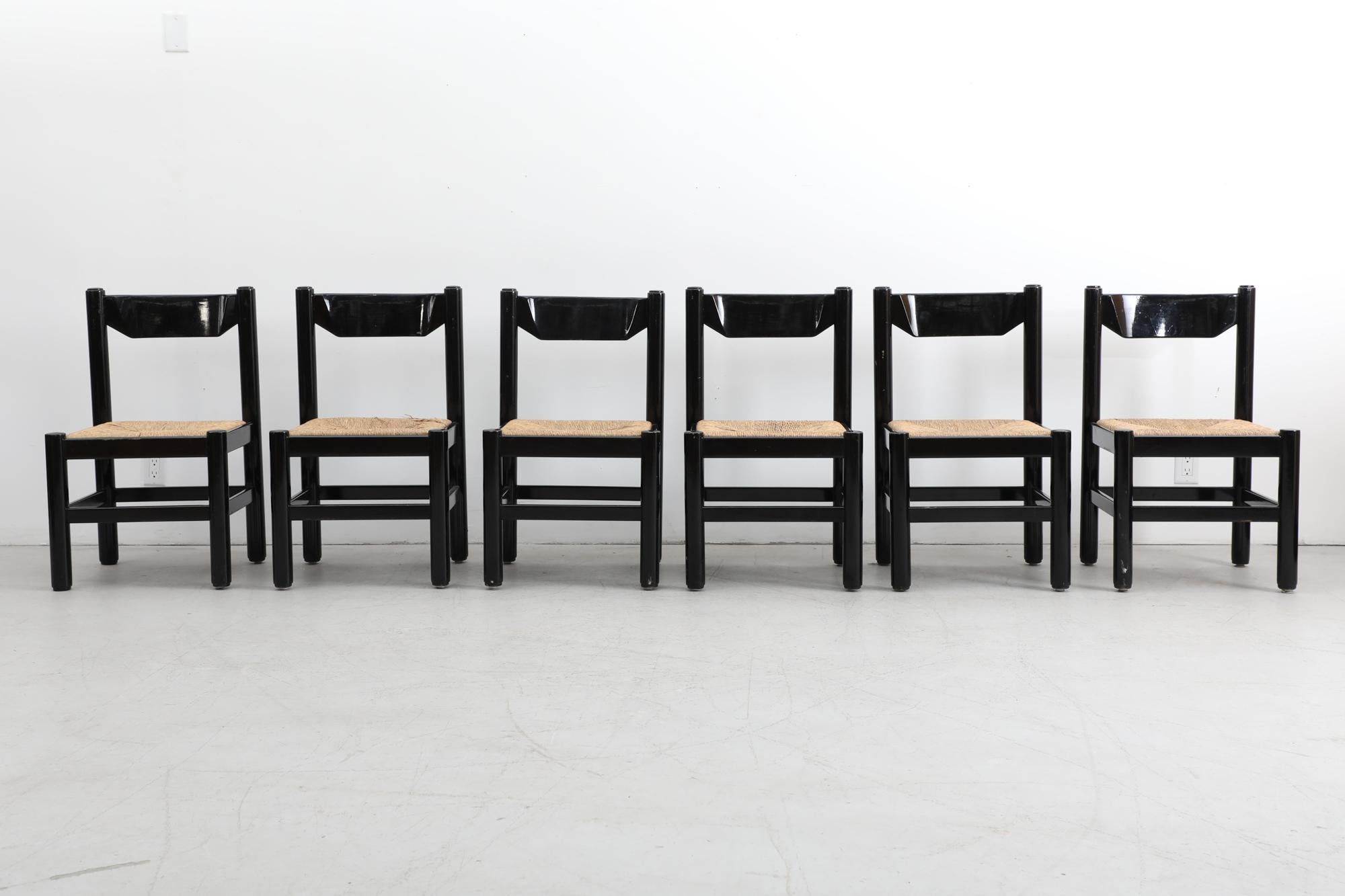 Set of 6 Vico Magistretti style side chairs with woven rush seats and black lacquered wood frames. The rush seats fit snugly inside the frames and are not fastened to the chairs. In original condition with some visible wear consistent with their age