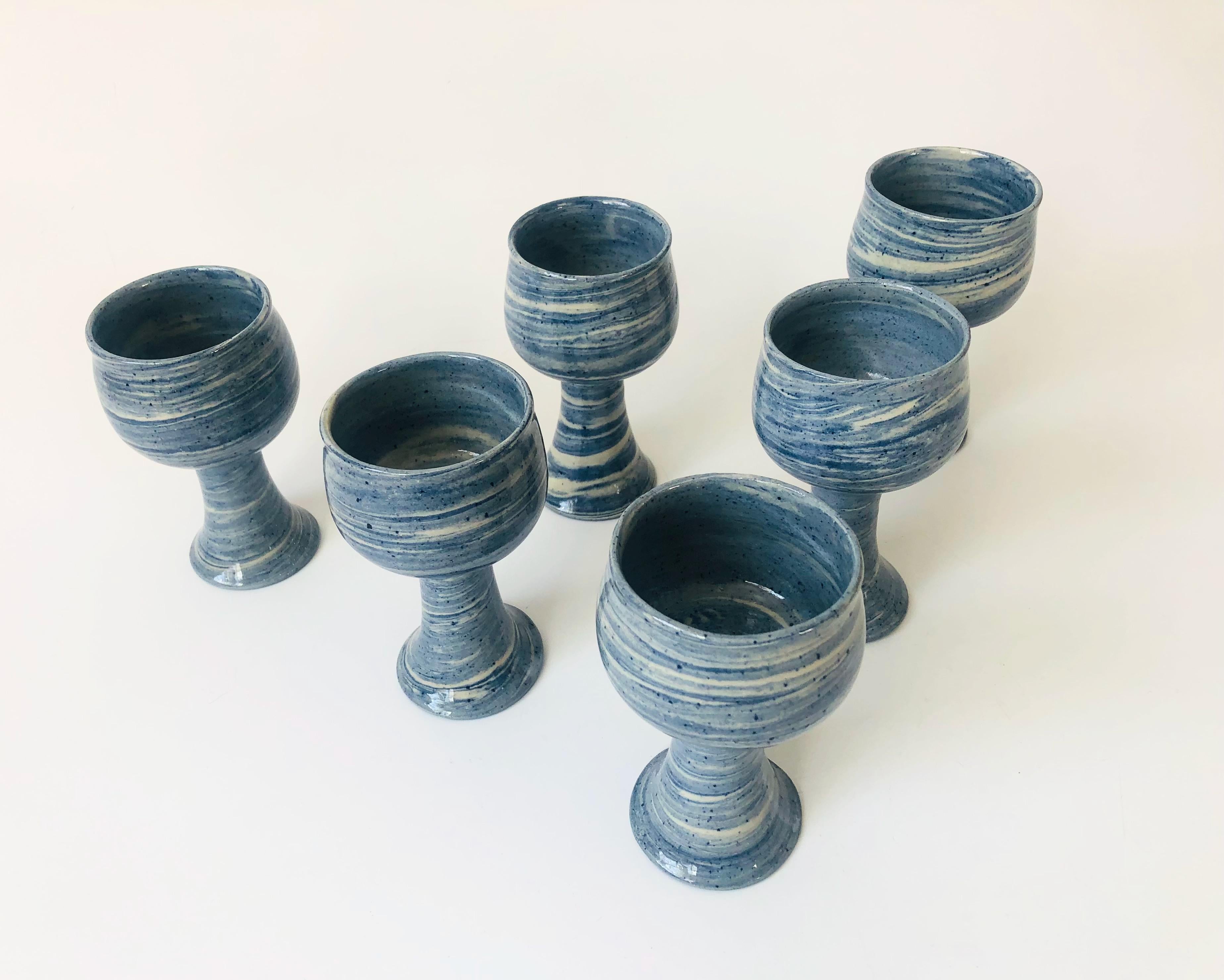 A set of 6 vintage studio pottery goblets. Lovely blue swirl glazes. Signed by the maker on the bases and dated 1977.
 