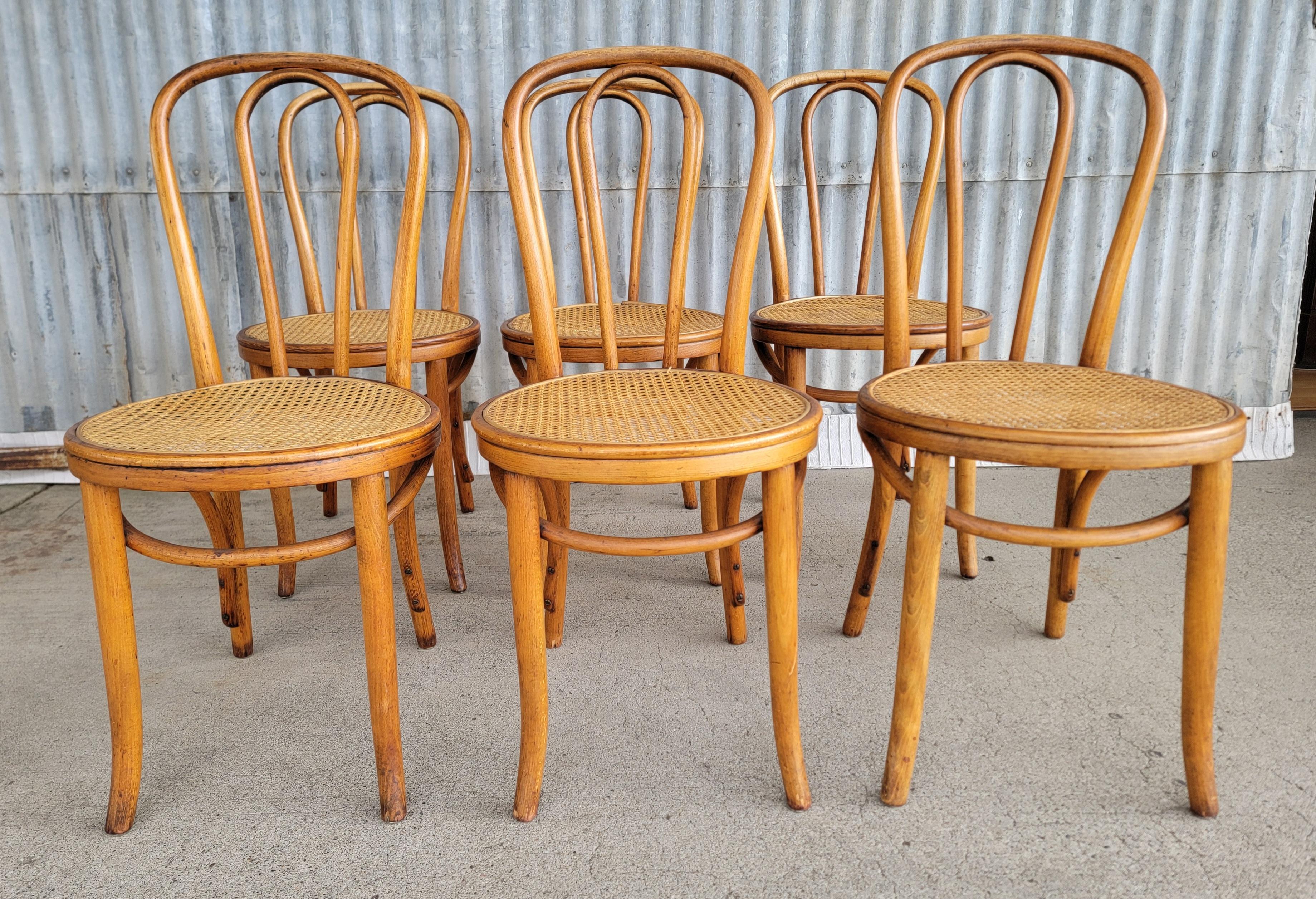 A set of 6 bentwood dining chairs with cane seats. Bistro, cafe, ice cream style, circa. 1920's. Beautiful and warm glow to patina and finish. Each chair branded 