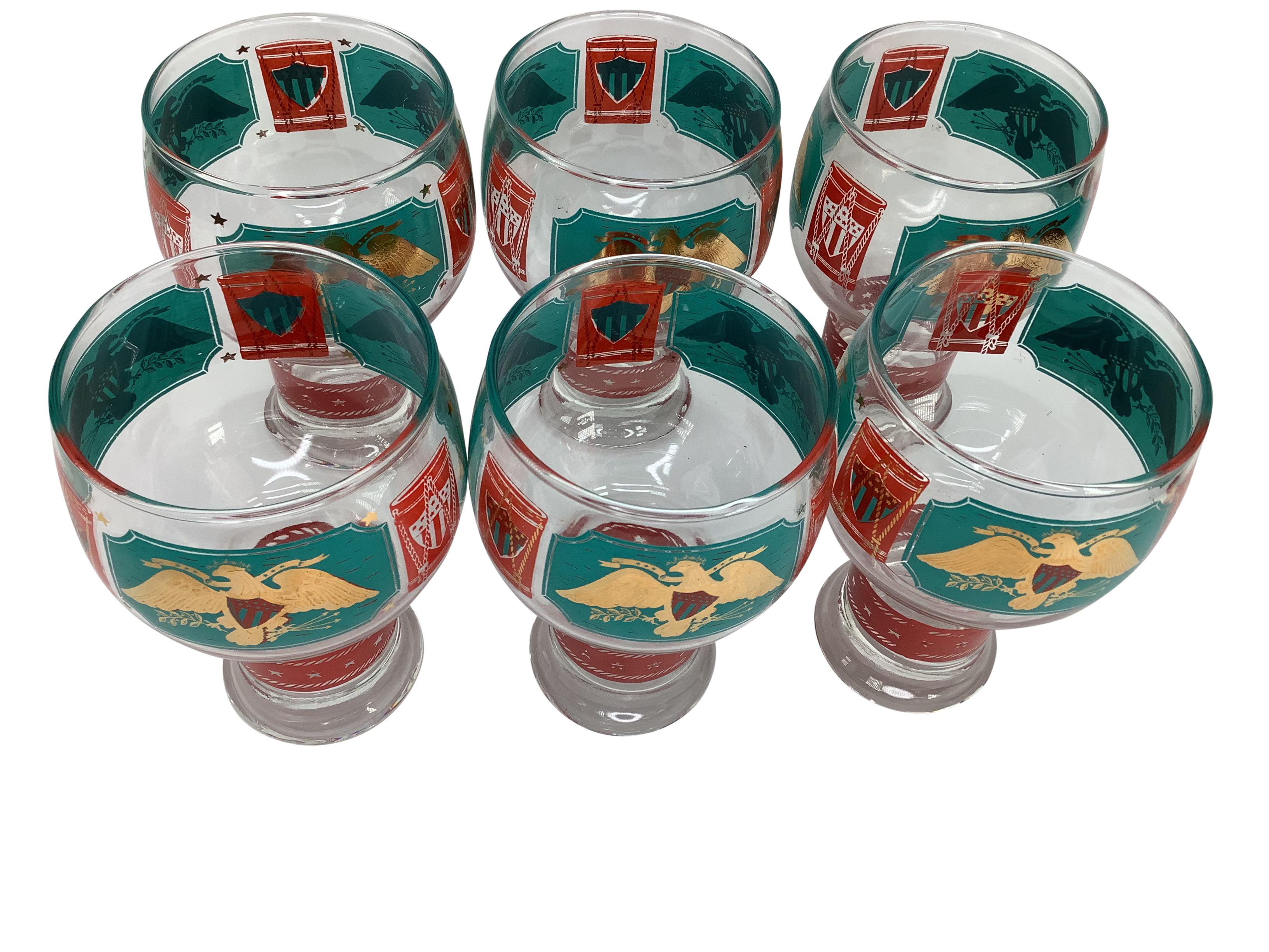 Set of 6 Mid-Century Modern Cera beer glasses in teal and red enamel with 22 karat gold. Decorated with gilt eagles, shields, and stars. Glasses measure 5 1/2