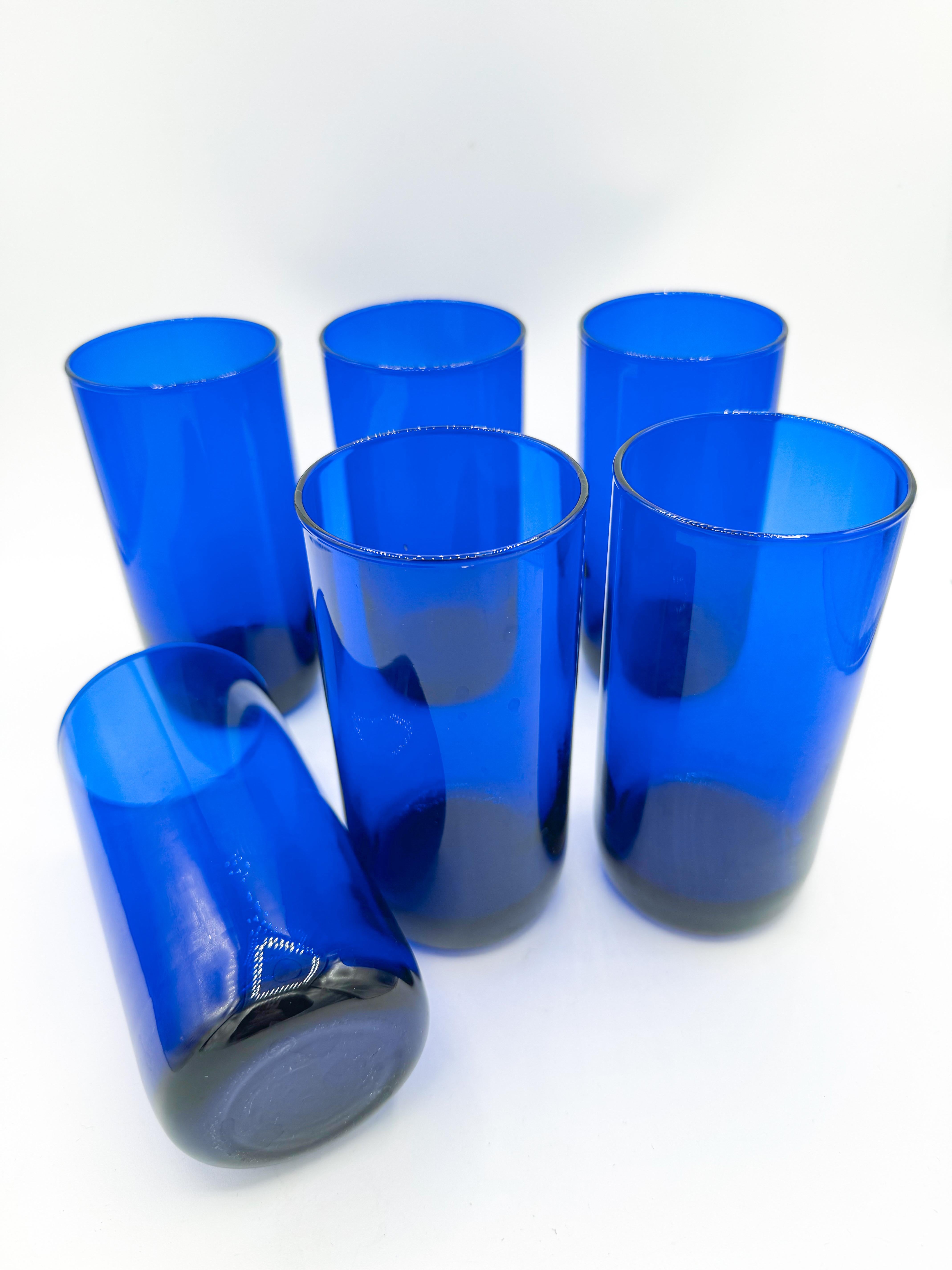 Elevate your barware collection with this striking set of six vintage cobalt blue highball tumblers from the 1980s. Hand-blown with precision and care, these glasses feature a rich, deep cobalt hue with a beautiful degrade finish—darker at the base