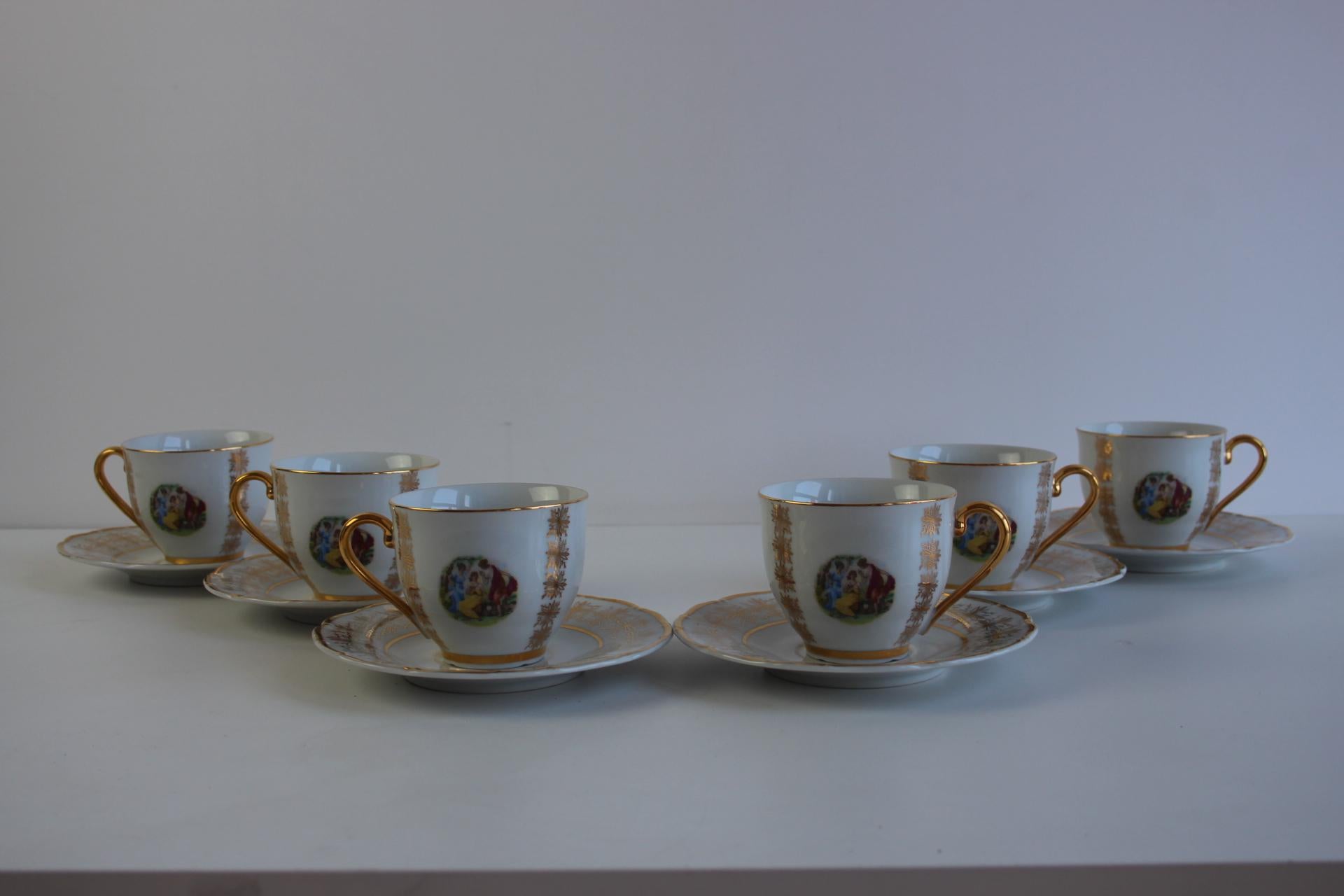 A refined set of 6 vintage porcelain demitasse cups and matching saucers, made by EPIAG in Czechoslovakia in the 1950s. Each piece features a Rococo-style romantic scene and decorative gilded details on the rims and handles (not real gold). A