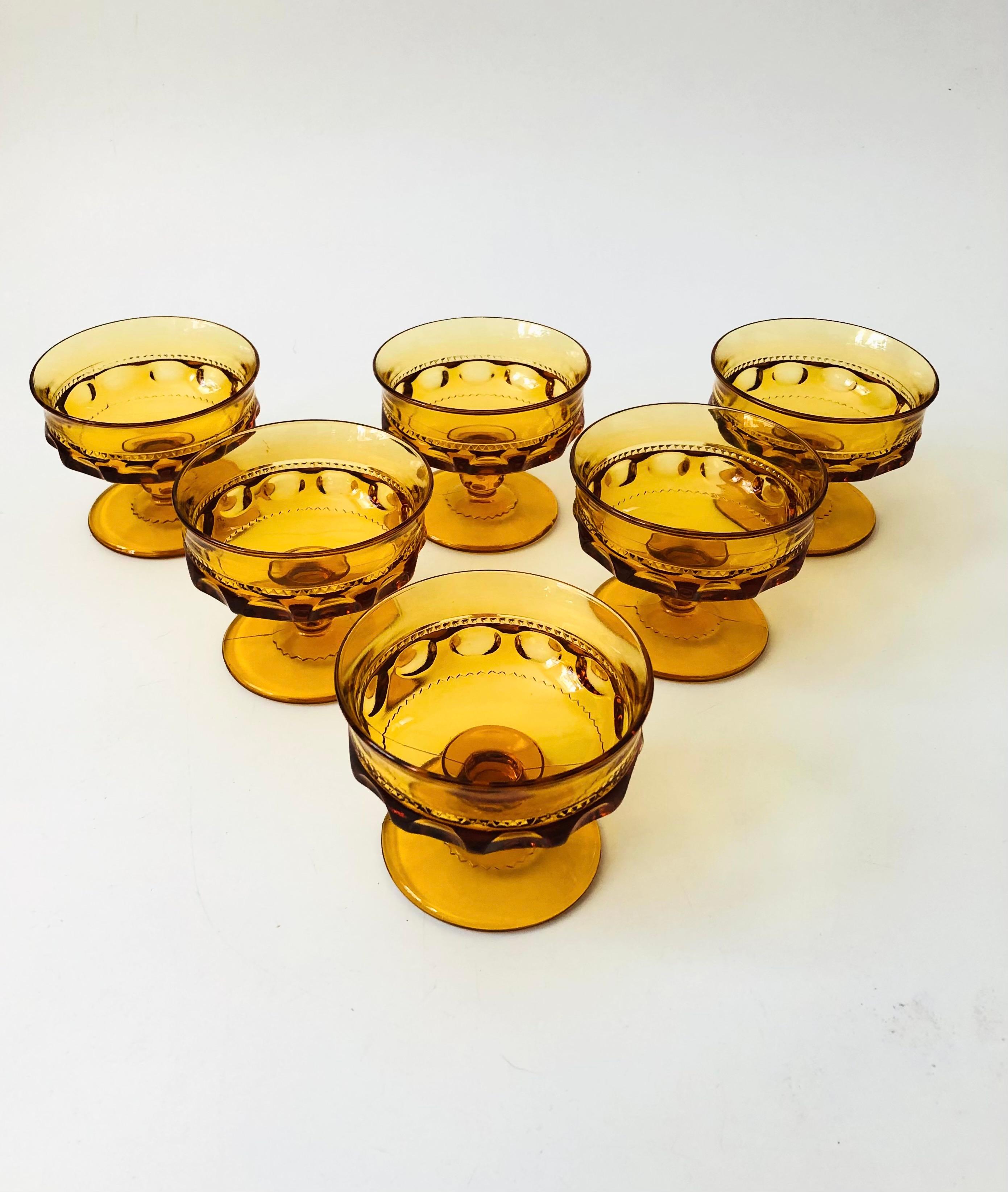 A set of 6 gorgeous coupe glasses with a lovely ornate design in amber glass. Made in the King's Crown pattern by Indiana Glass. Perfect for champagne, wine, or cocktails.