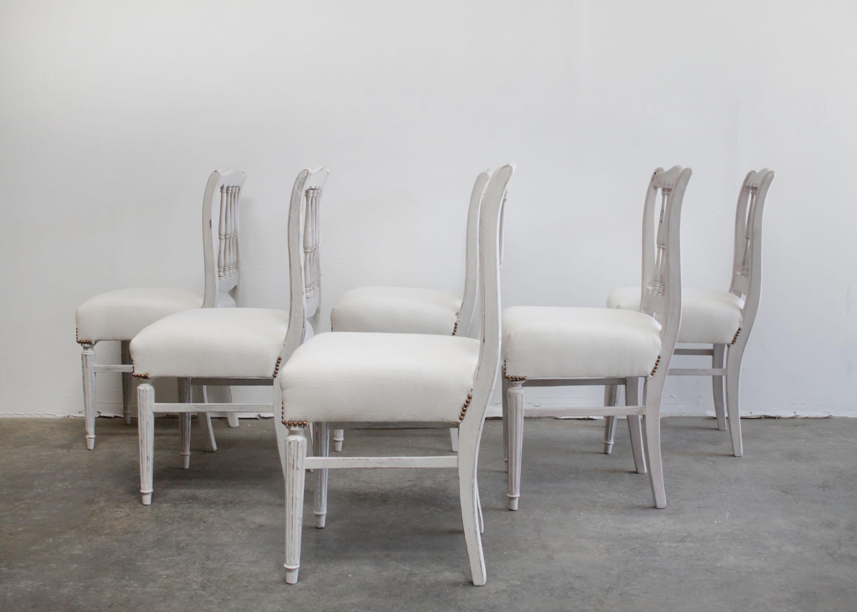 Beautiful vintage painted dining chairs with a spindle back.
Painted in a soft oyster gray, in multi tones, and subtle antique distressed edges.
Chairs are solid and sturdy, the seats are very comfortable.
Has a brass nail trim. We can upholster or