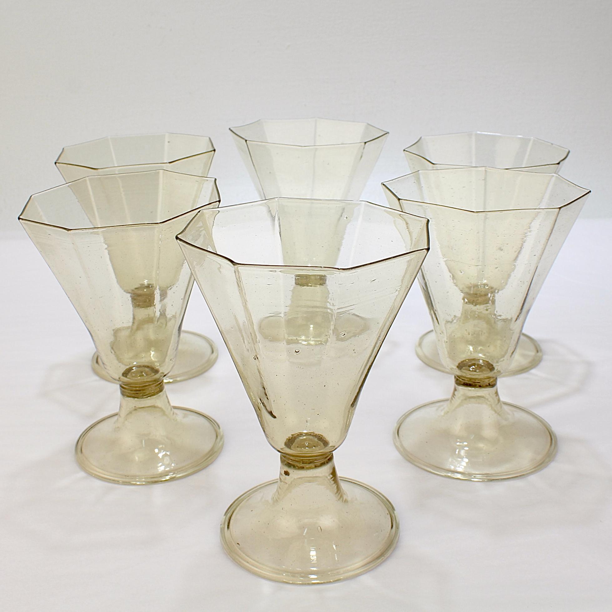 A fine set of vintage Venetian glass wine glasses.

With a delicate octagonal cup supported by an inverted trumpet form base with a folded foot. 

In amber glass with captured bubbles sprinkled throughout. 

Simply a wonderful